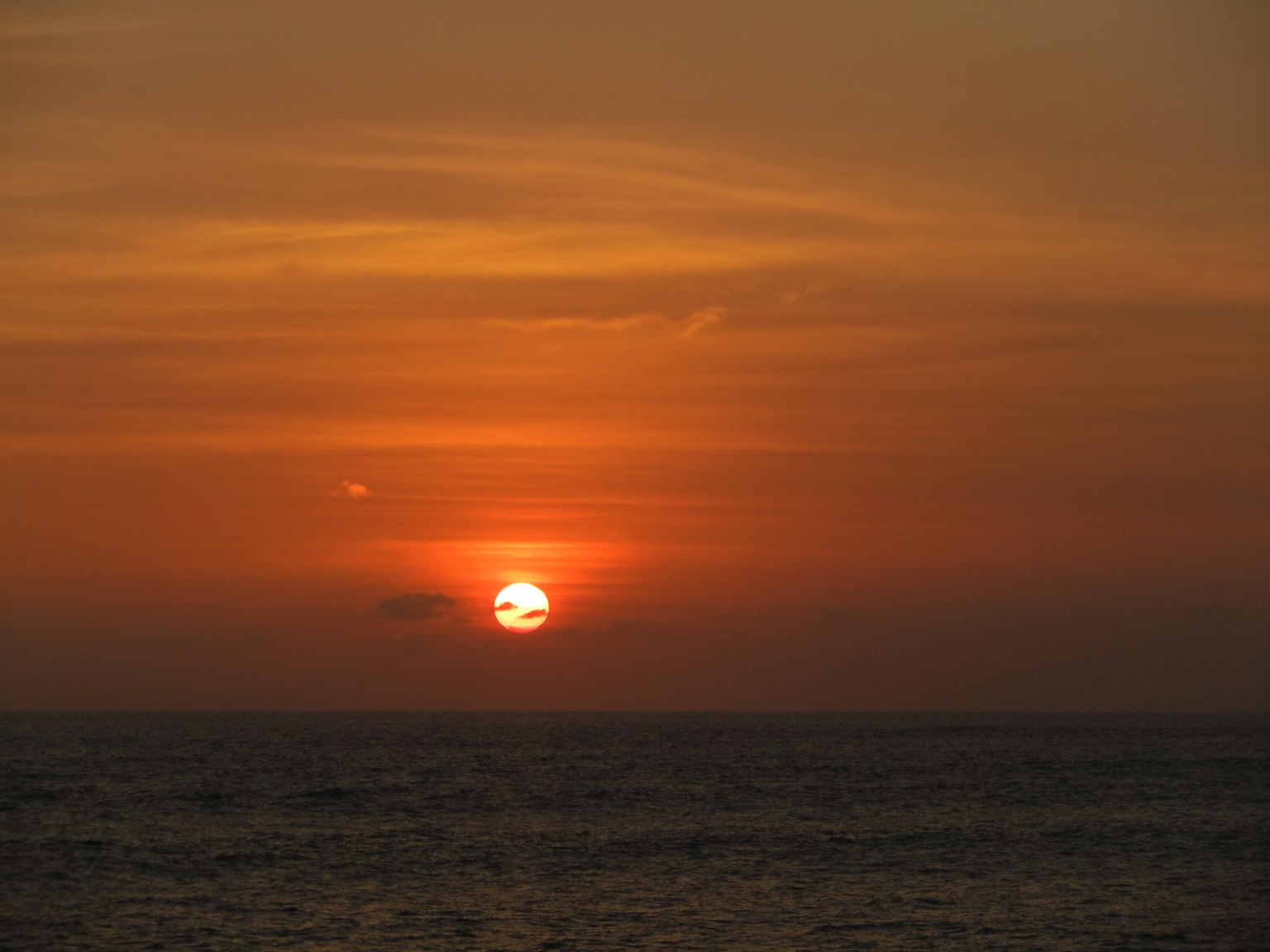 Hermoso atardecer sobre el océano con cielo naranja y rojo