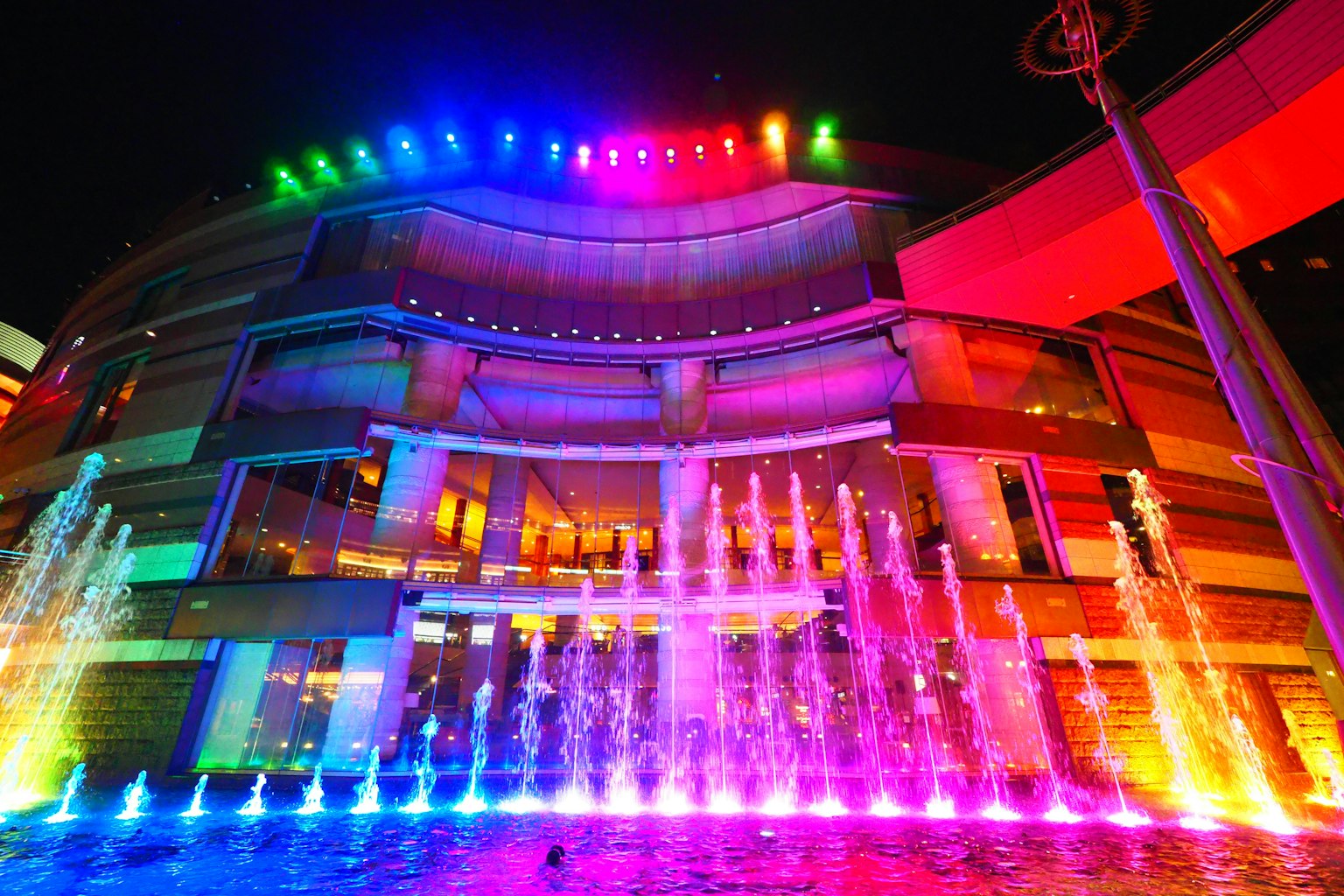 夜晚现代建筑前的五彩斑斓的喷泉
