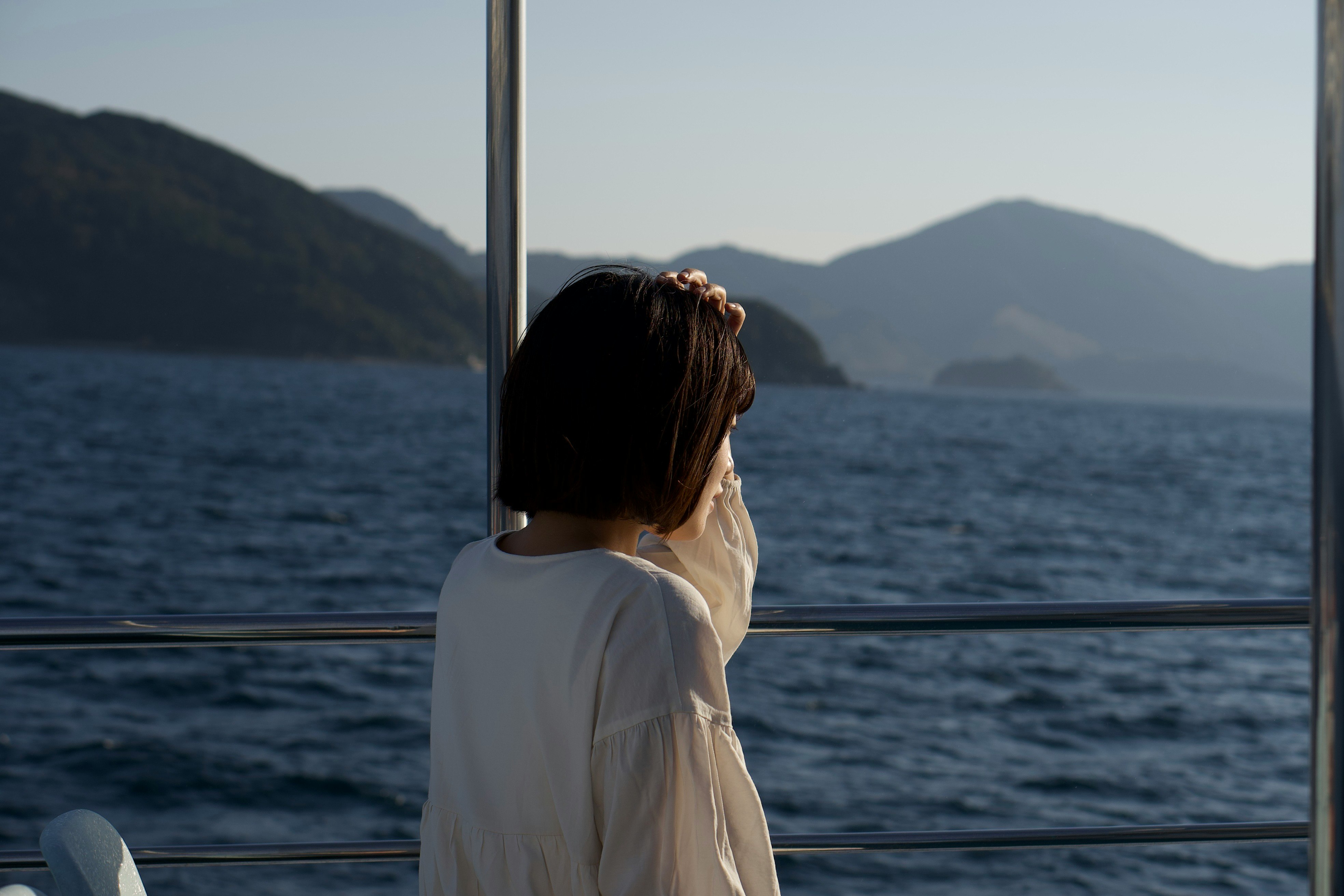海を望む船上で窓辺に立つ女性