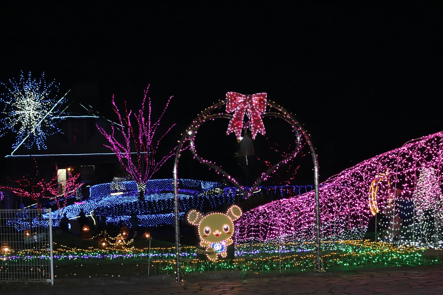 Vibrant night scene featuring colorful lights and a bear character