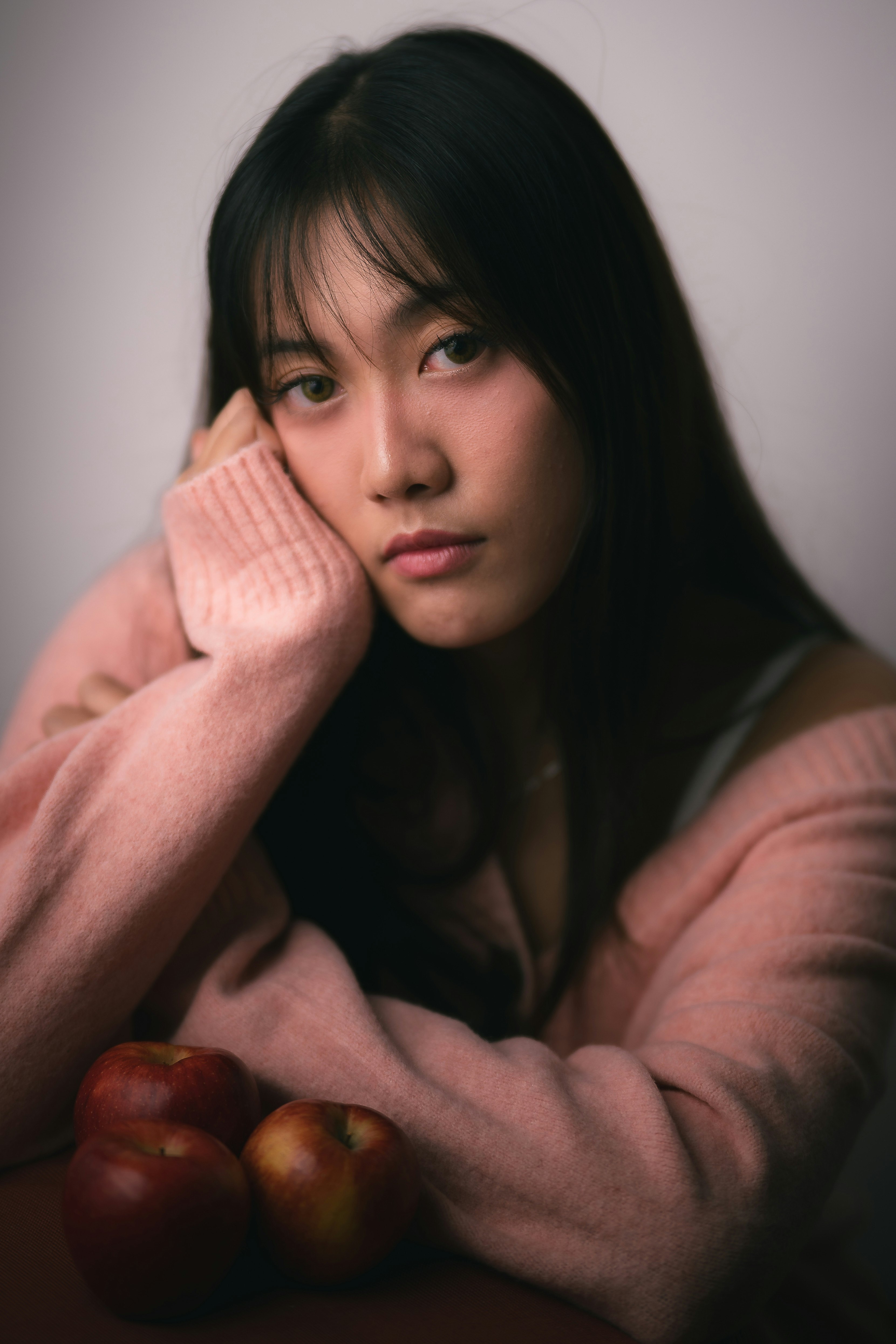 りんごを手に頬杖をつく女性のポートレート