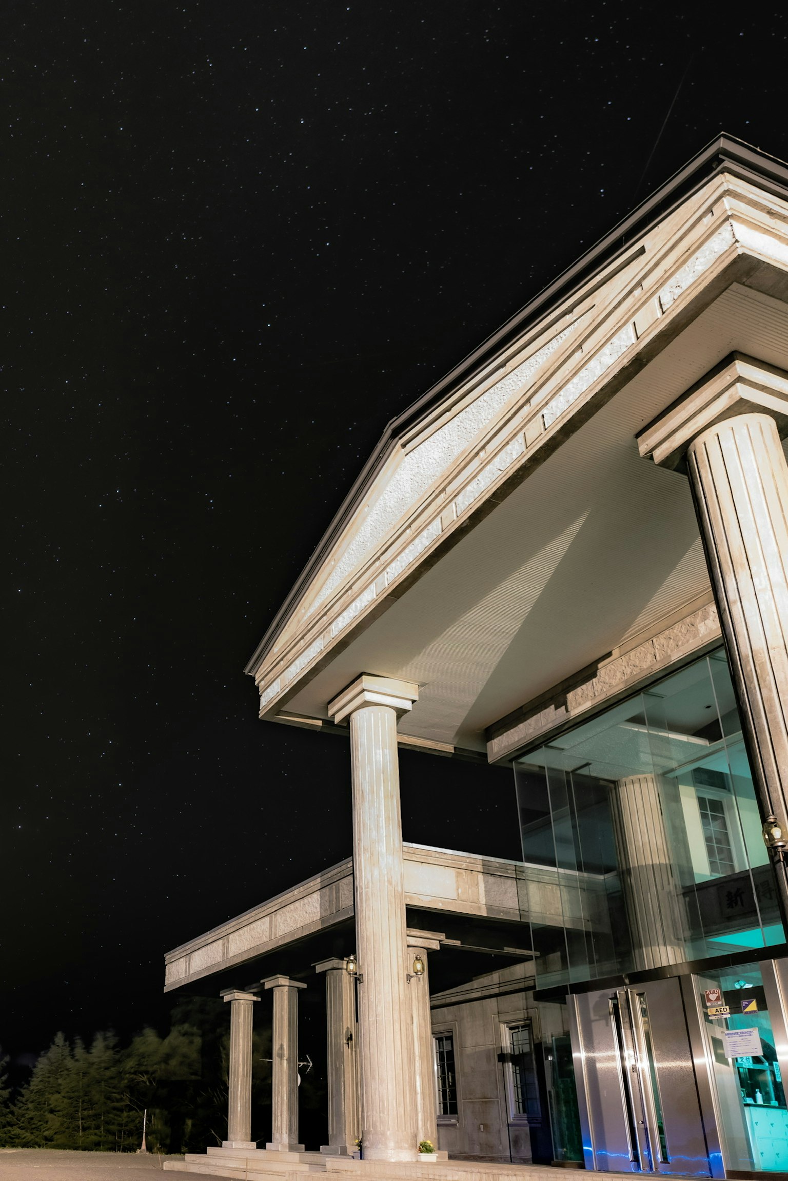 Façade d'un bâtiment moderne avec des colonnes sur fond d'un ciel étoilé