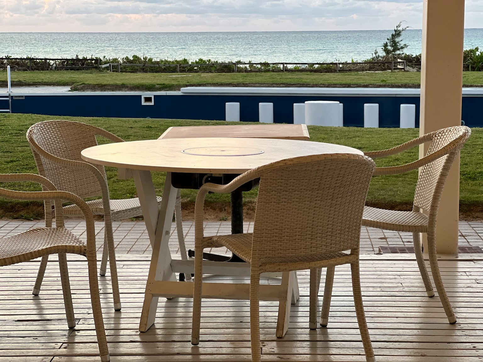 Table et chaises blanches en extérieur avec vue sur la mer