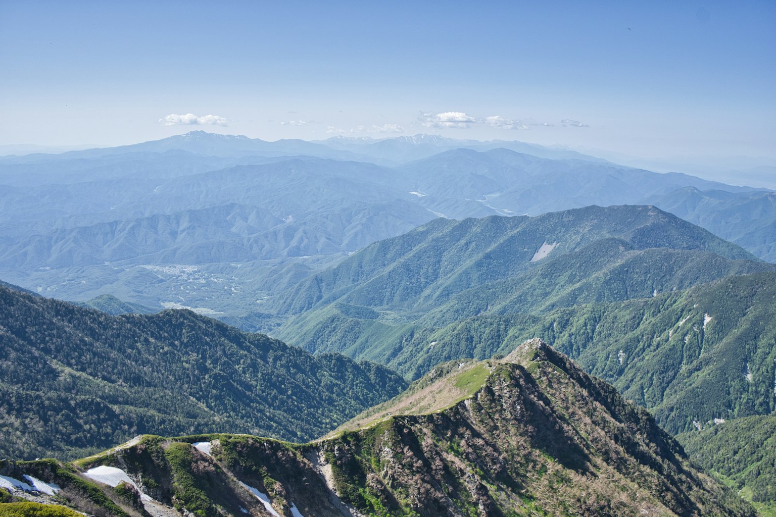 清澈蓝天下的绿色山脉风景和遥远的山峰