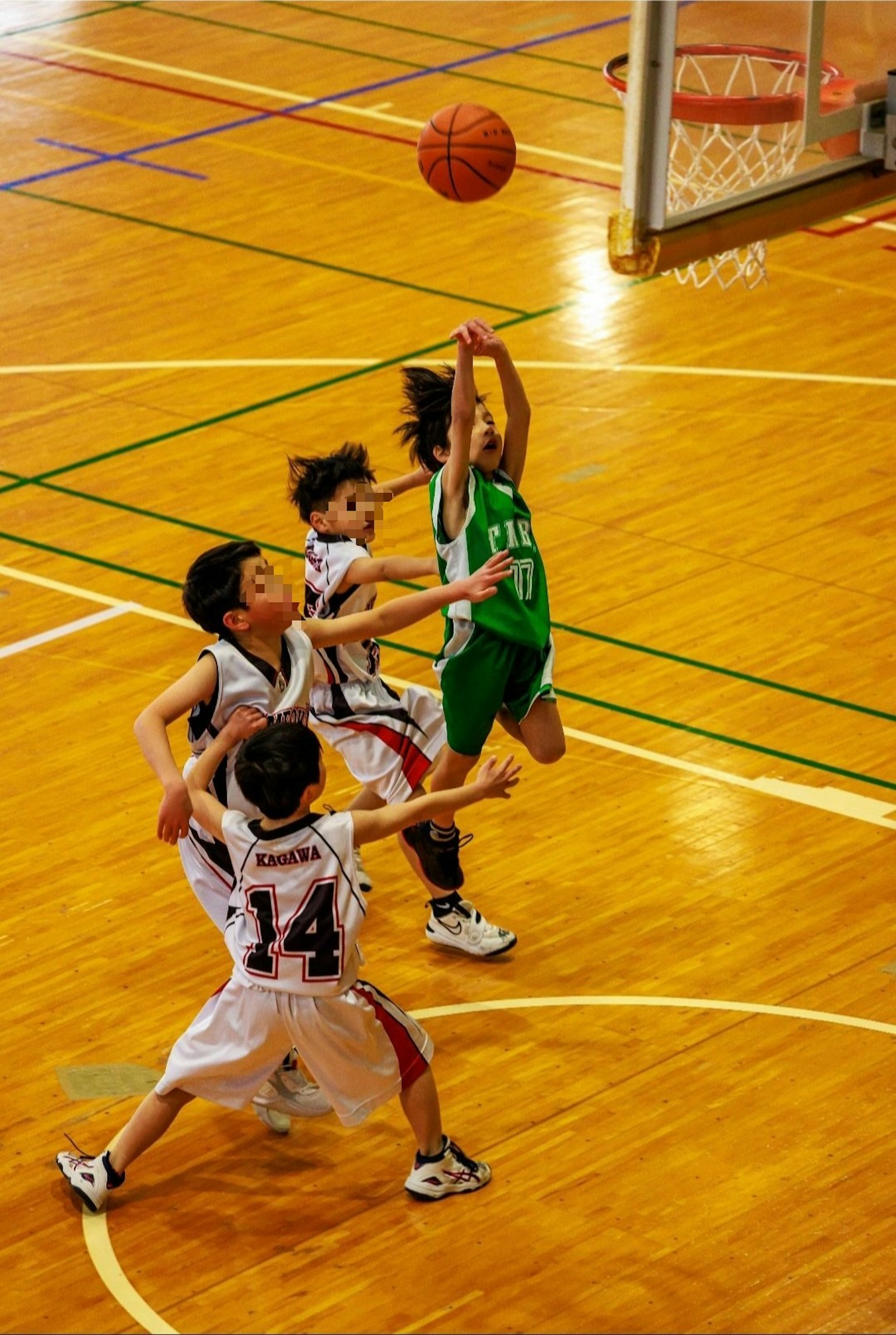 Bambini che giocano a basket durante una partita con un giocatore che tenta un tiro