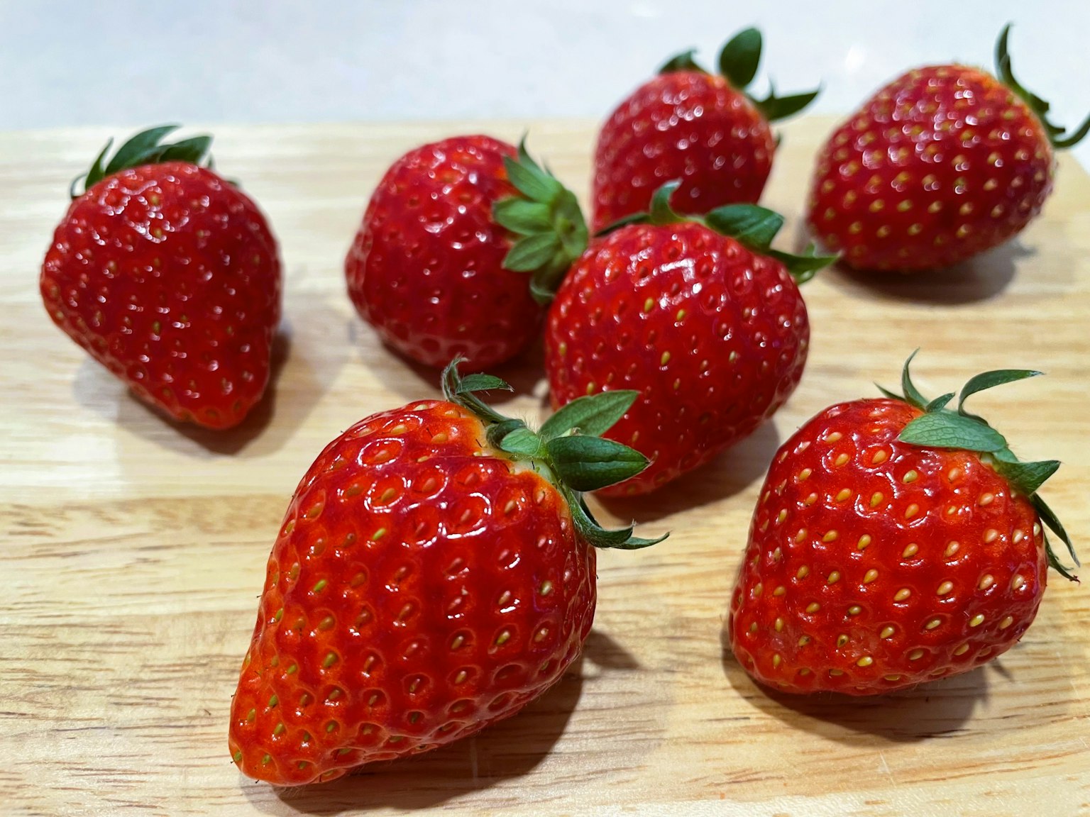 Fraises rouges vives disposées sur une planche en bois