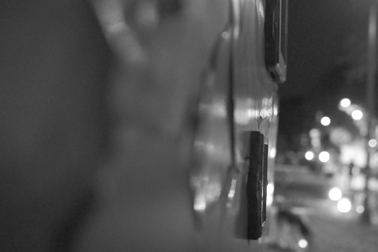 夜の街のぼやけた背景に近づいた車の側面