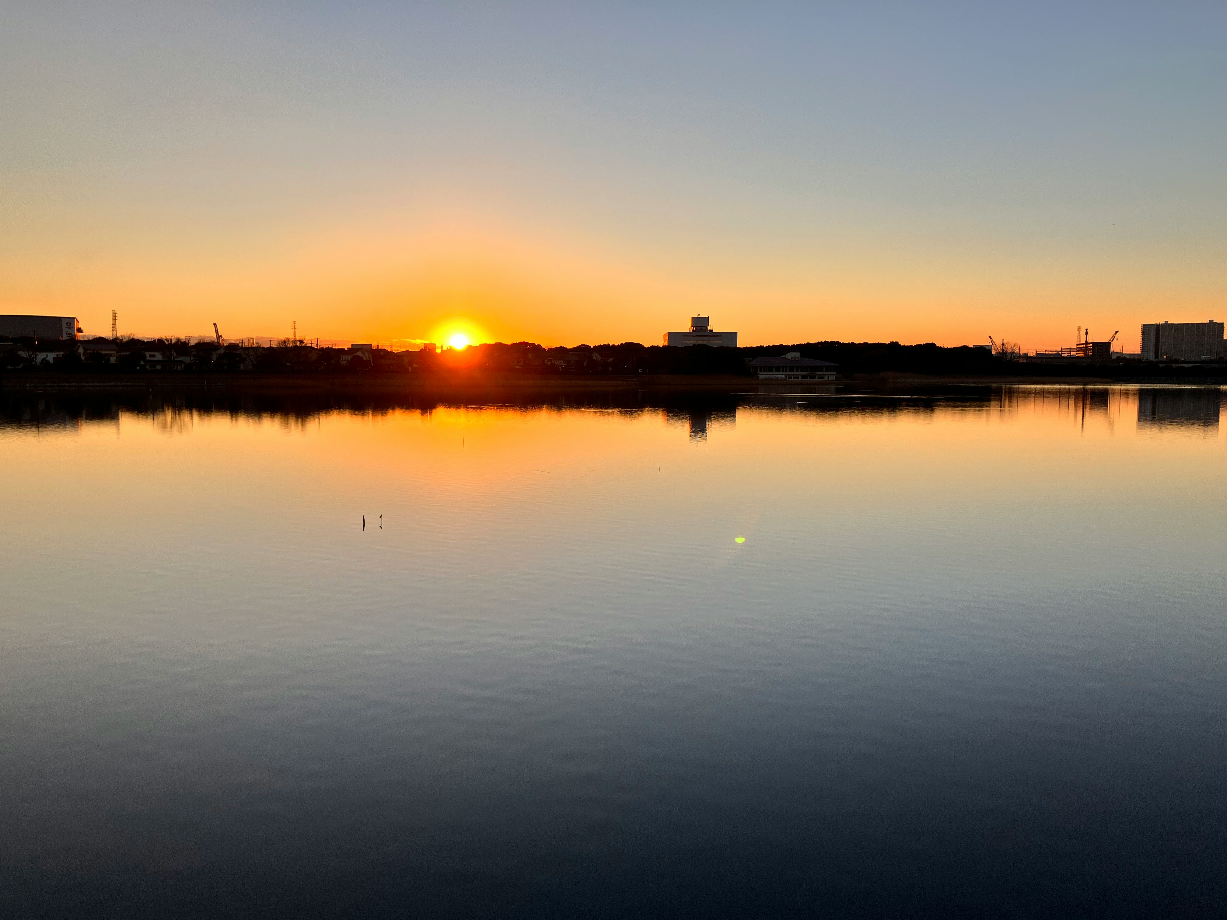干潟の夕陽が水面に映る冬の風景