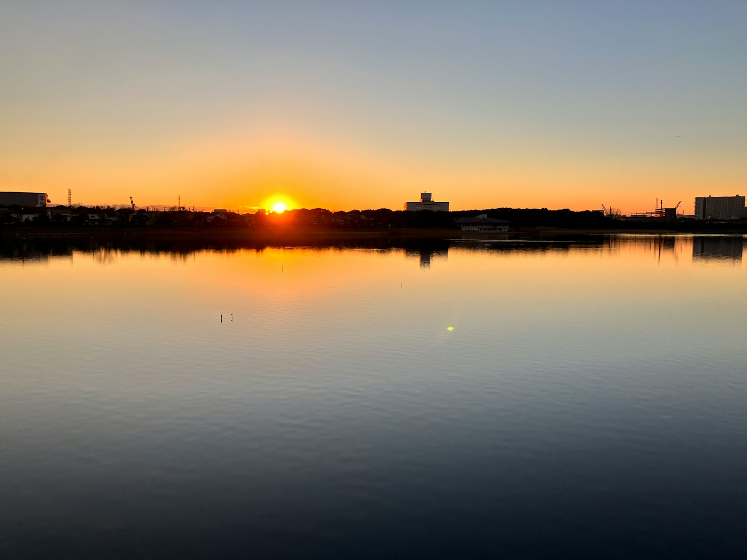 Wunderschöner Sonnenuntergang, der sich auf einem ruhigen See mit sanften Himmelstönen spiegelt
