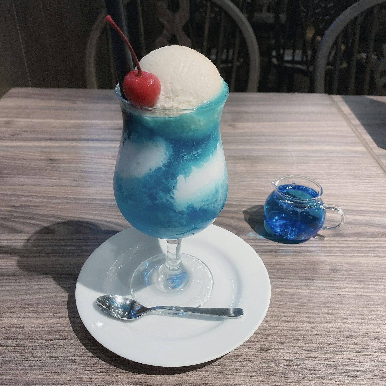 Blue drink dessert with ice cream topped with a cherry