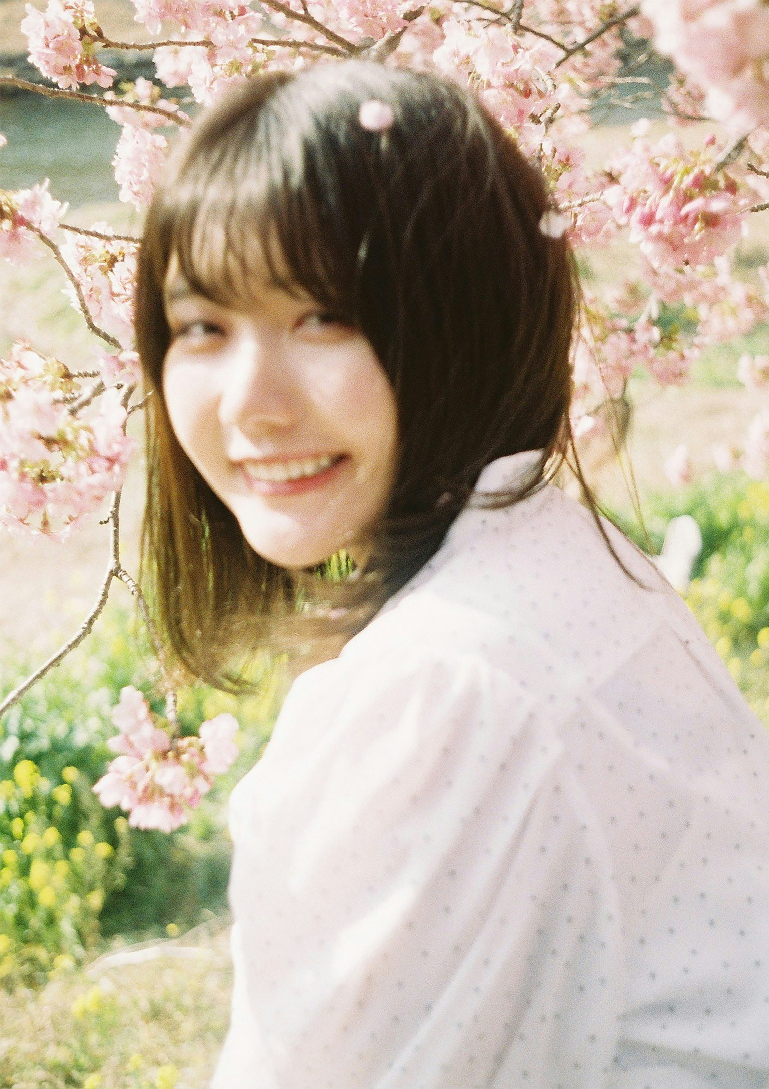 桜の花の咲く庭で微笑む女性