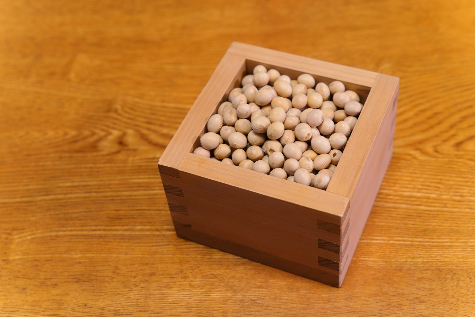 Una caja de madera llena de pequeñas esferas blancas