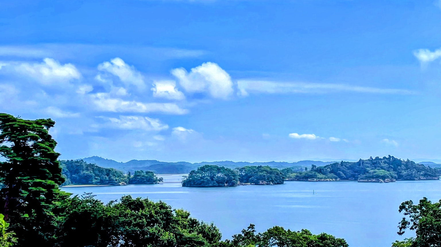 Malersicher Blick auf einen See mit kleinen Inseln unter blauem Himmel