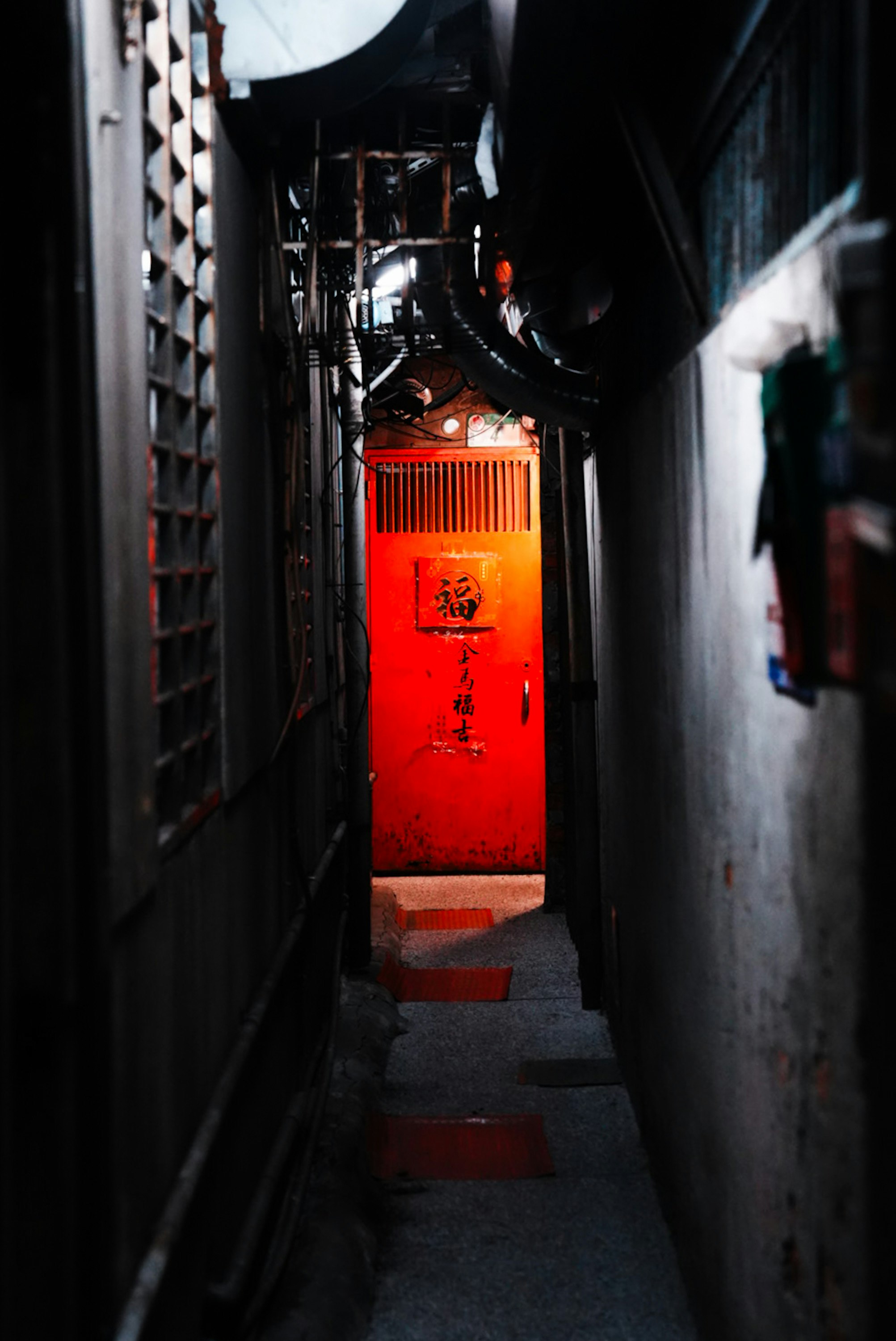 narrow alley passage with a red lantern glowing near a gate