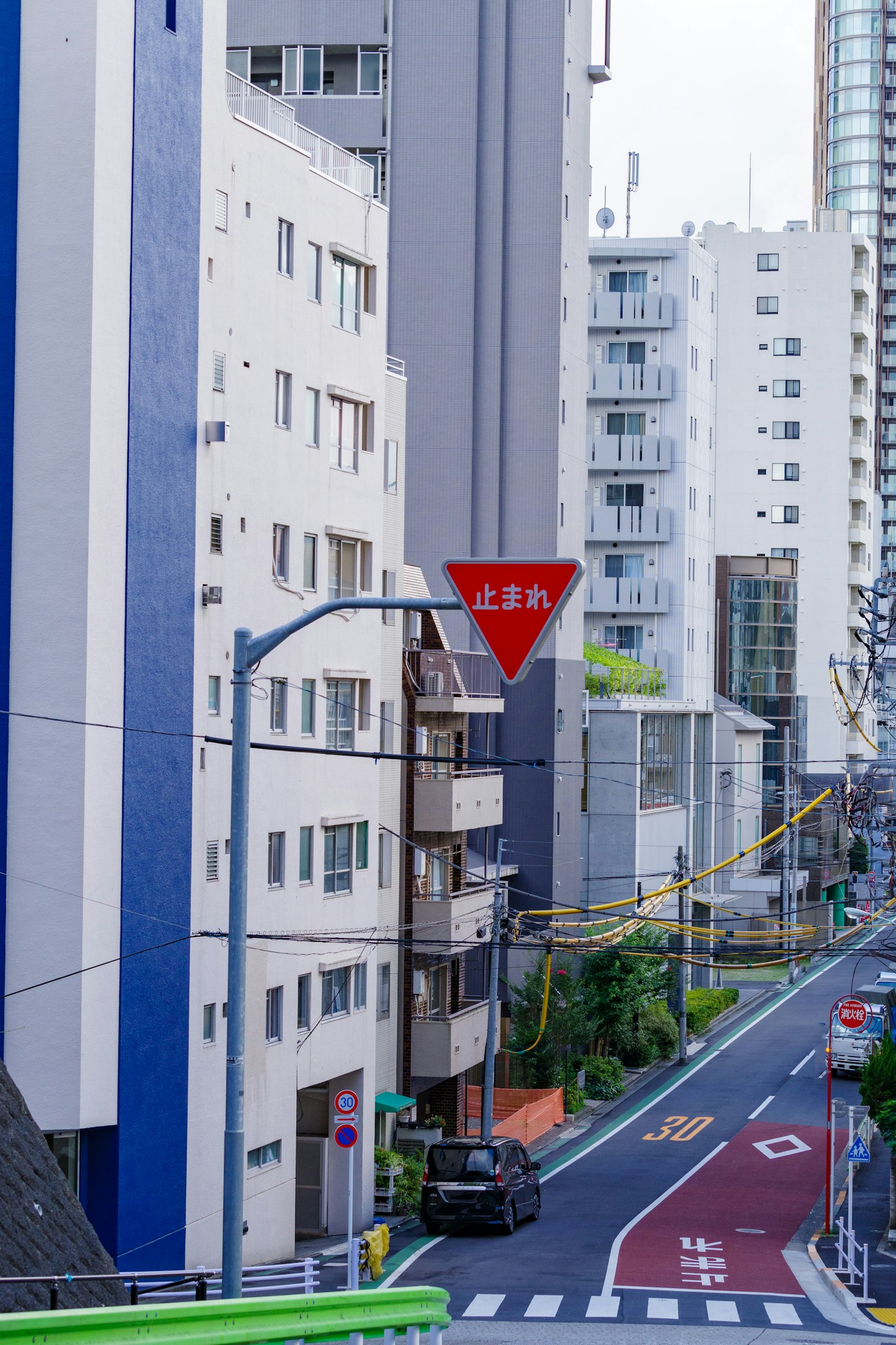 Señal de ceda el paso triangular roja en una calle urbana con edificios circundantes