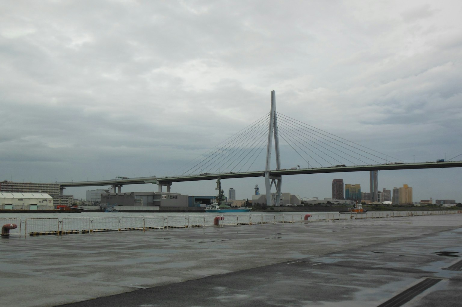 Moderne Brücke und Hafenansicht unter bewölktem Himmel