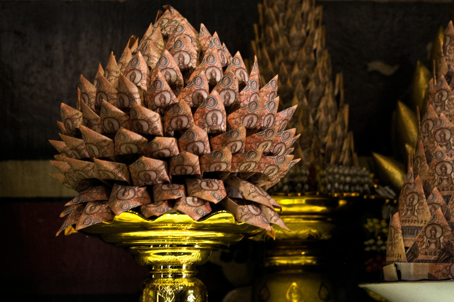 Objek dekoratif berbentuk Buddha dikelilingi oleh elemen emas