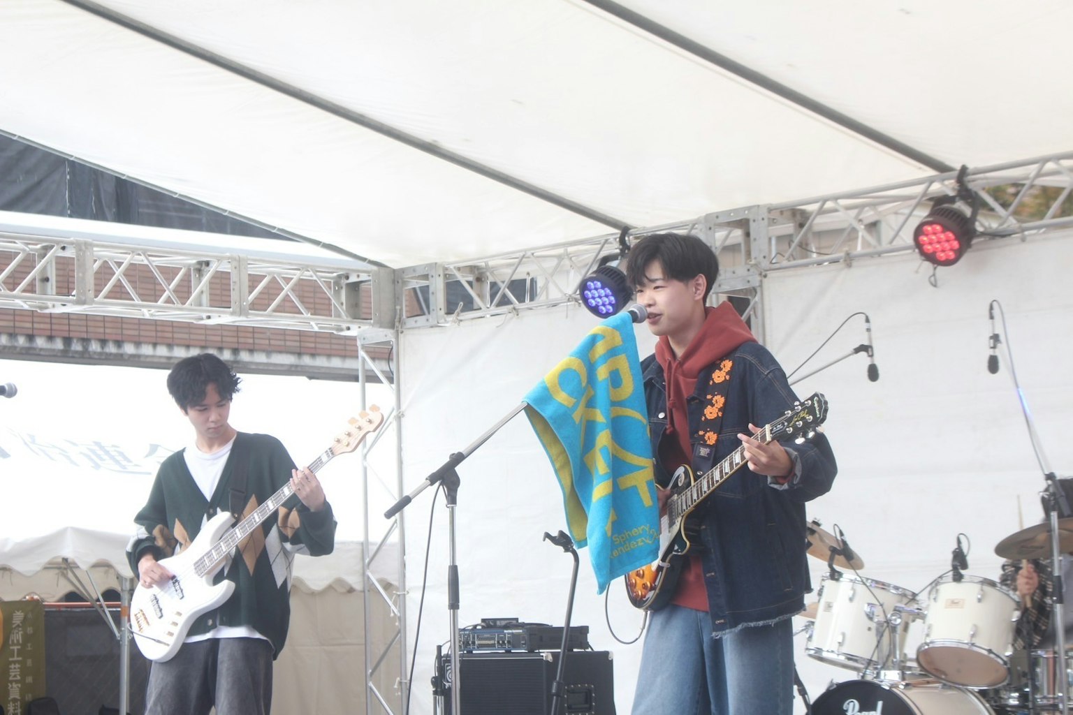 Miembros de una banda actuando en vivo en el escenario con una bandera
