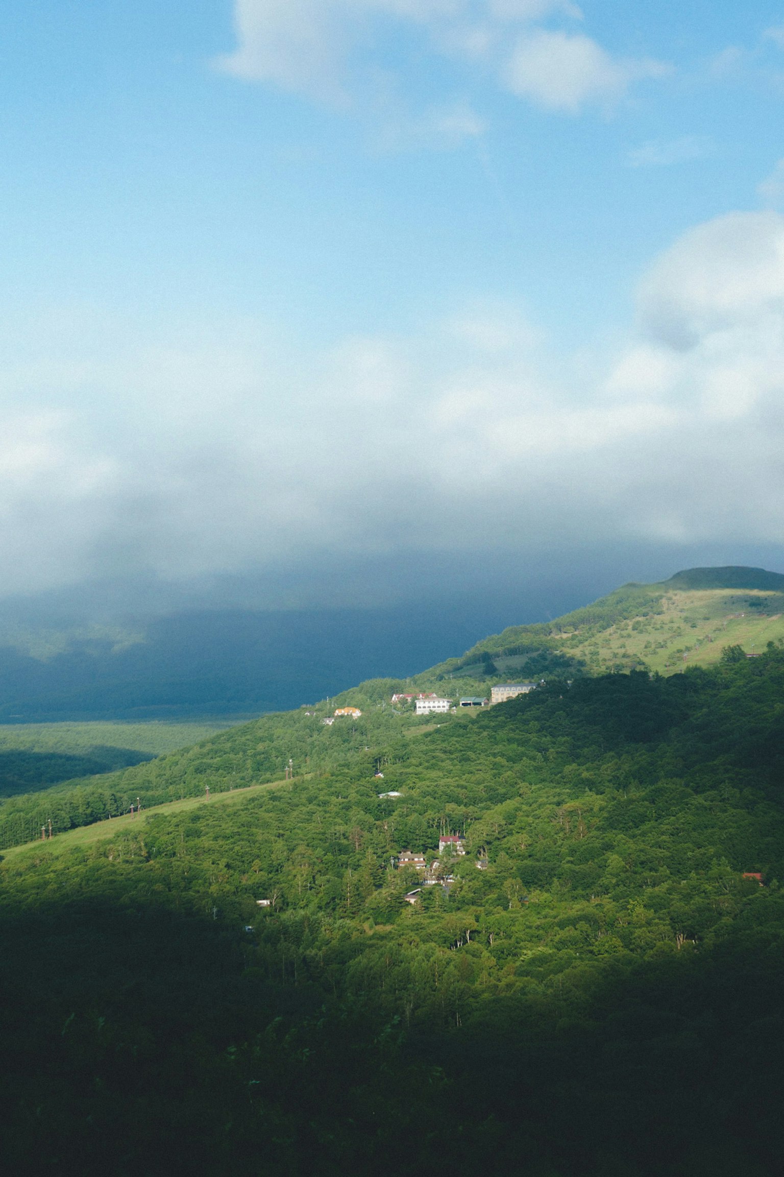 藍天和雲下的郁郁蔥蔥的山丘景色