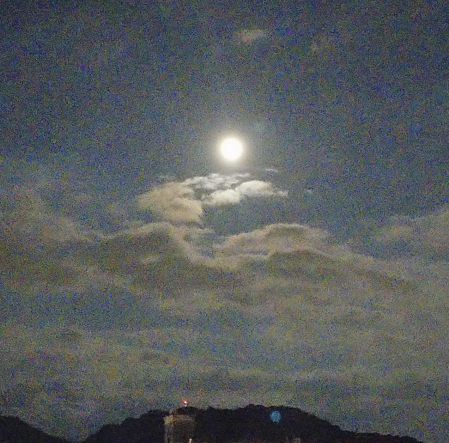 Ciel nocturne avec une pleine lune partiellement cachée par des nuages