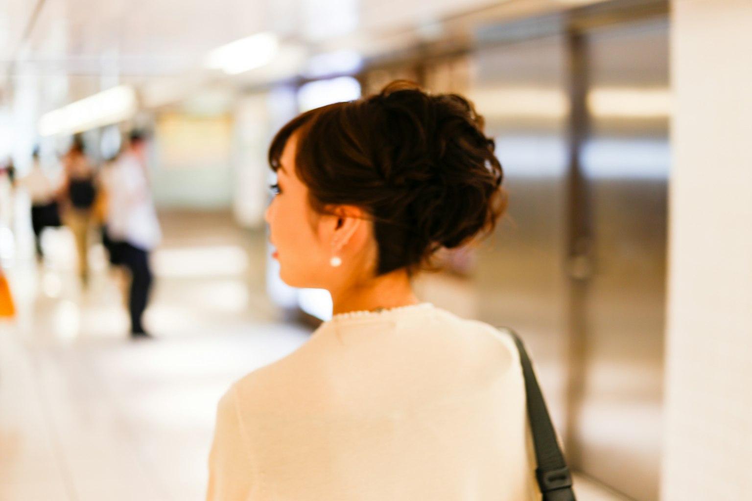 Femme vue de dos dans une station tenue décontractée et coiffure élégante