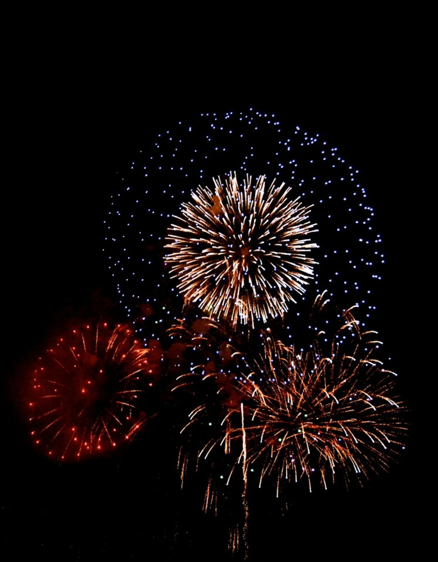 Hermoso espectáculo de fuegos artificiales en el cielo nocturno con patrones rojos y azules