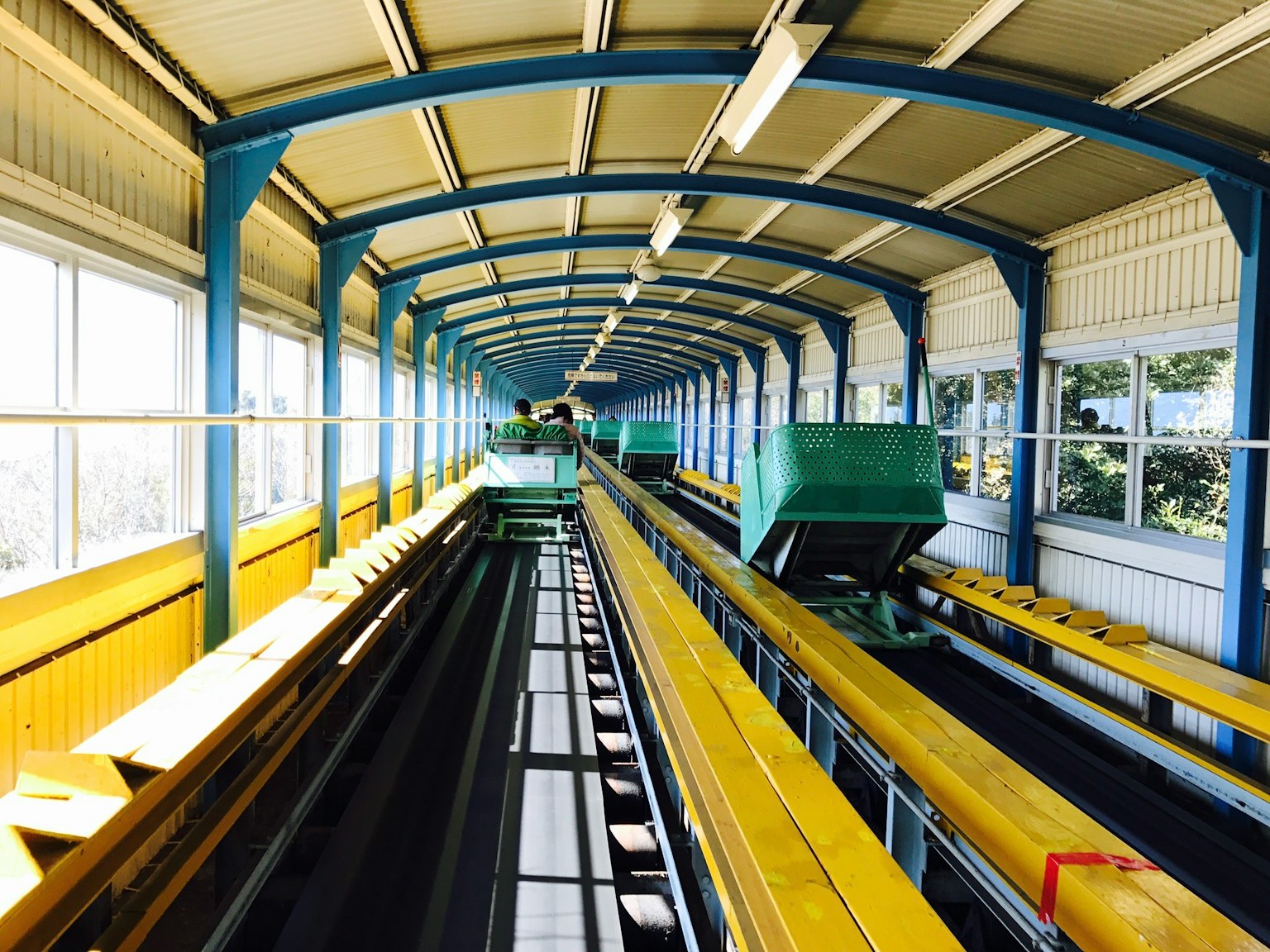 Couloir intérieur avec des chariots verts et des rails jaunes