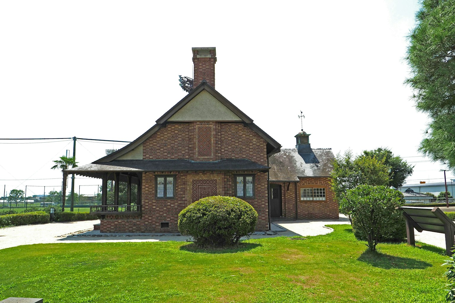 Casa de ladrillo rojo con césped verde y porche