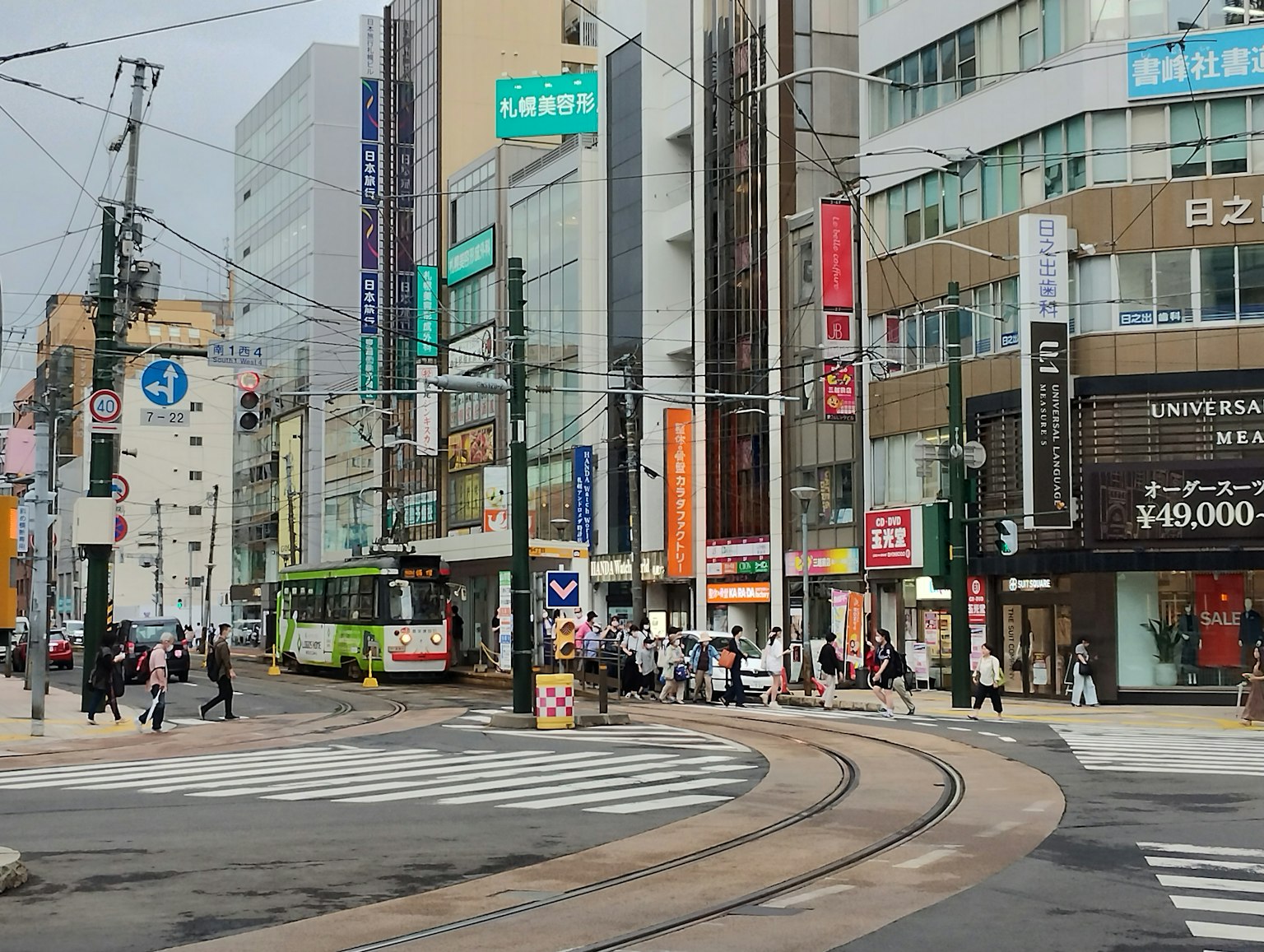 Persimpangan dengan rel trem dan gedung tinggi di daerah perkotaan yang ramai