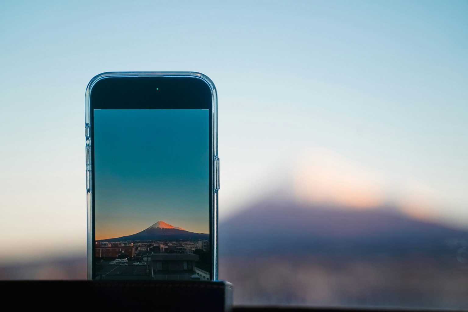 Smartphone displaying a mountain landscape with blurred mountains in the background
