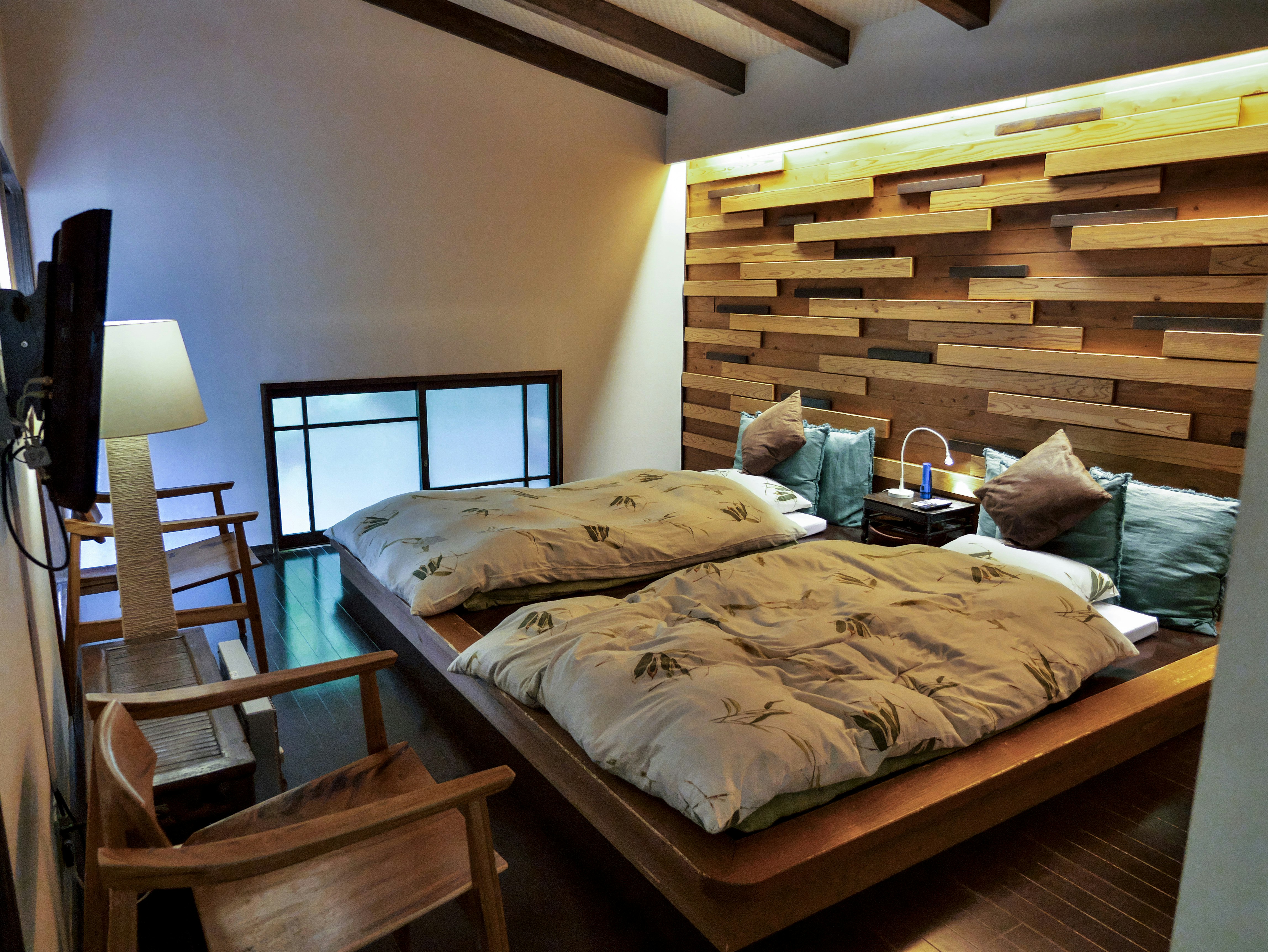 interior kamar tidur dengan ranjang kayu dan pencahayaan lembut