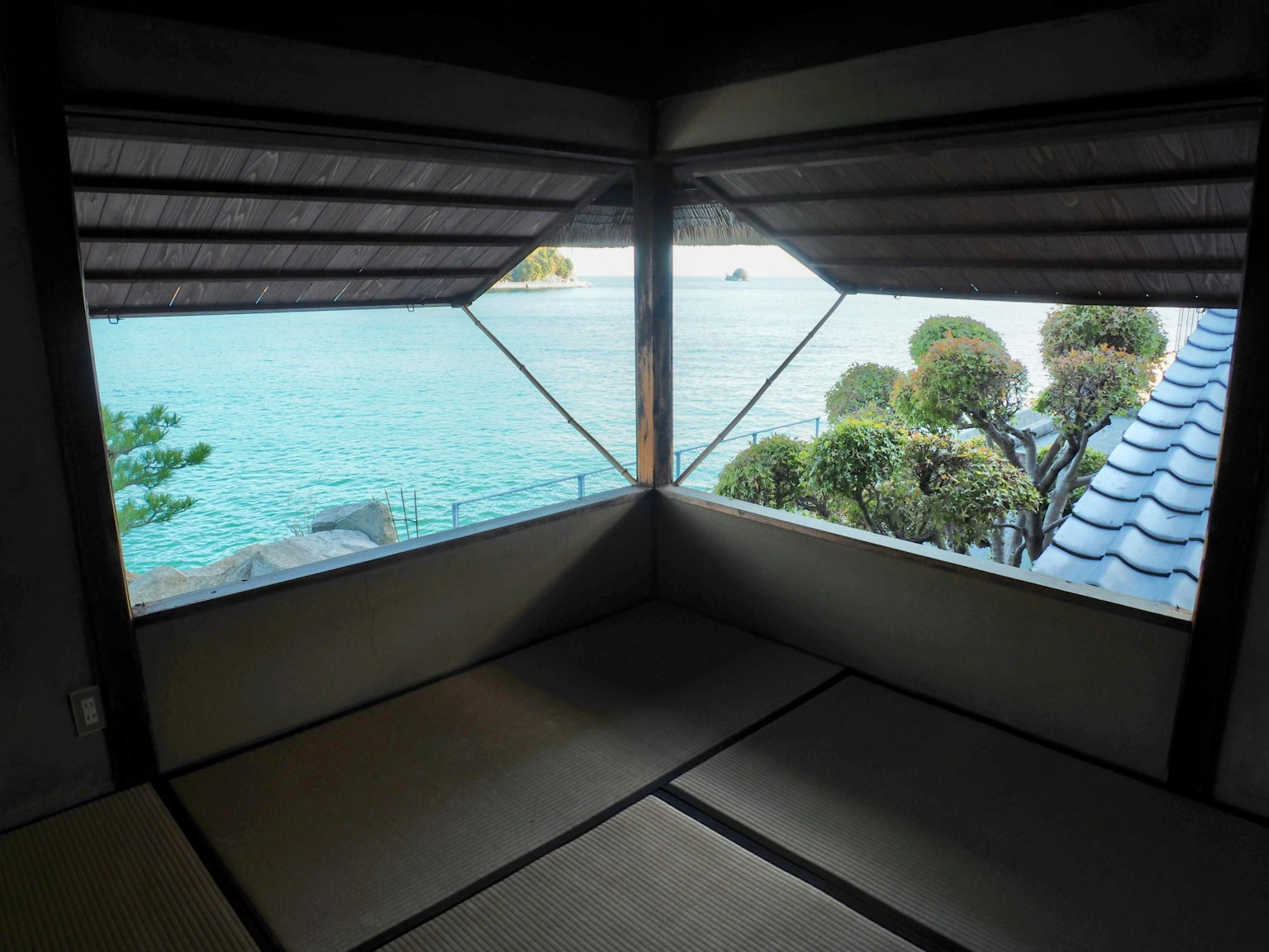 Vista da una stanza giapponese tradizionale che affaccia sul mare e sul verde