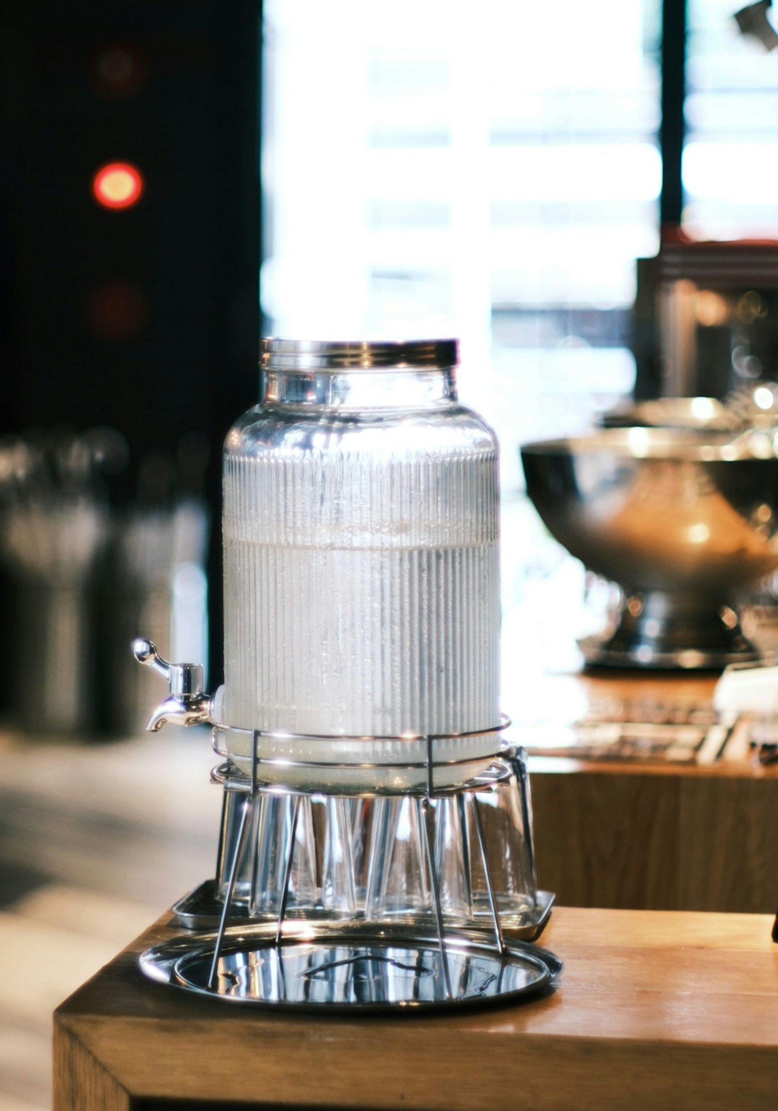Un distributeur d'eau transparent sur une table en bois