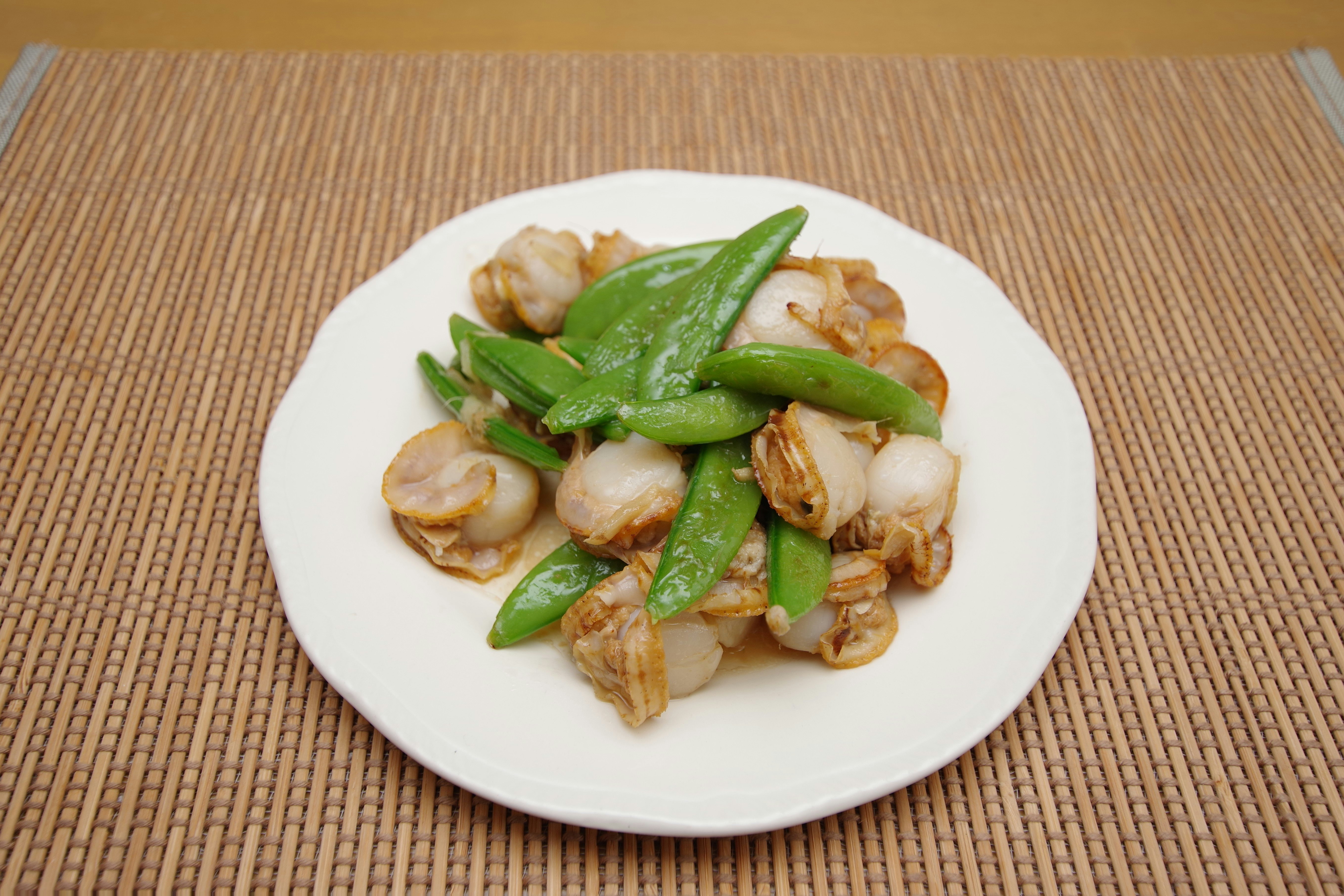 udang tumis dengan kacang polong di piring putih