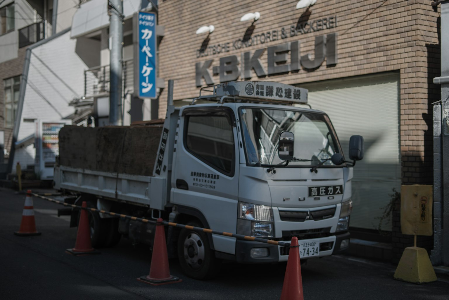 Camion bianco parcheggiato tra coni arancioni in un ambiente urbano
