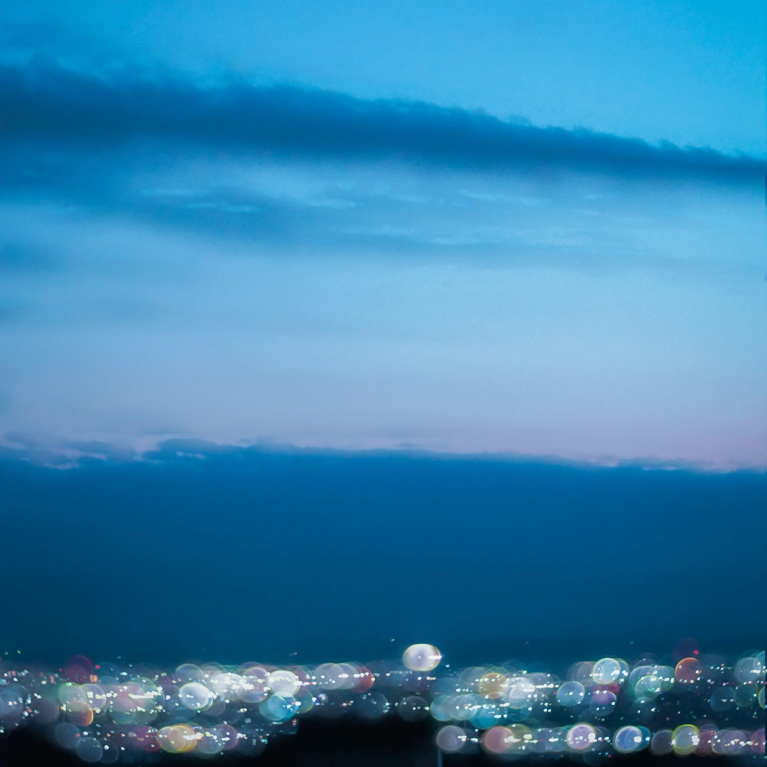 Paesaggio urbano notturno con cielo blu e luci della città sfocate