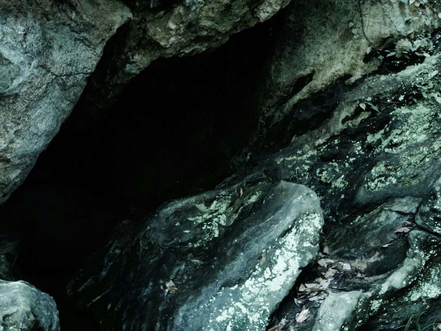 Dark cave entrance visible among rocky formations