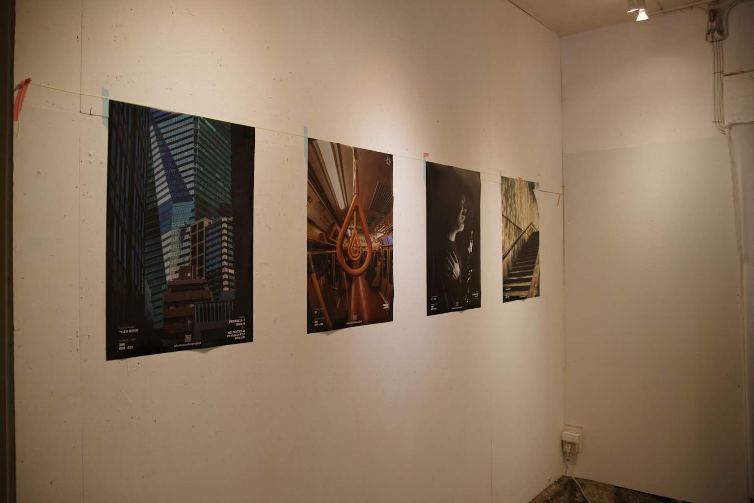 Four photographic artworks displayed on a modern gallery wall