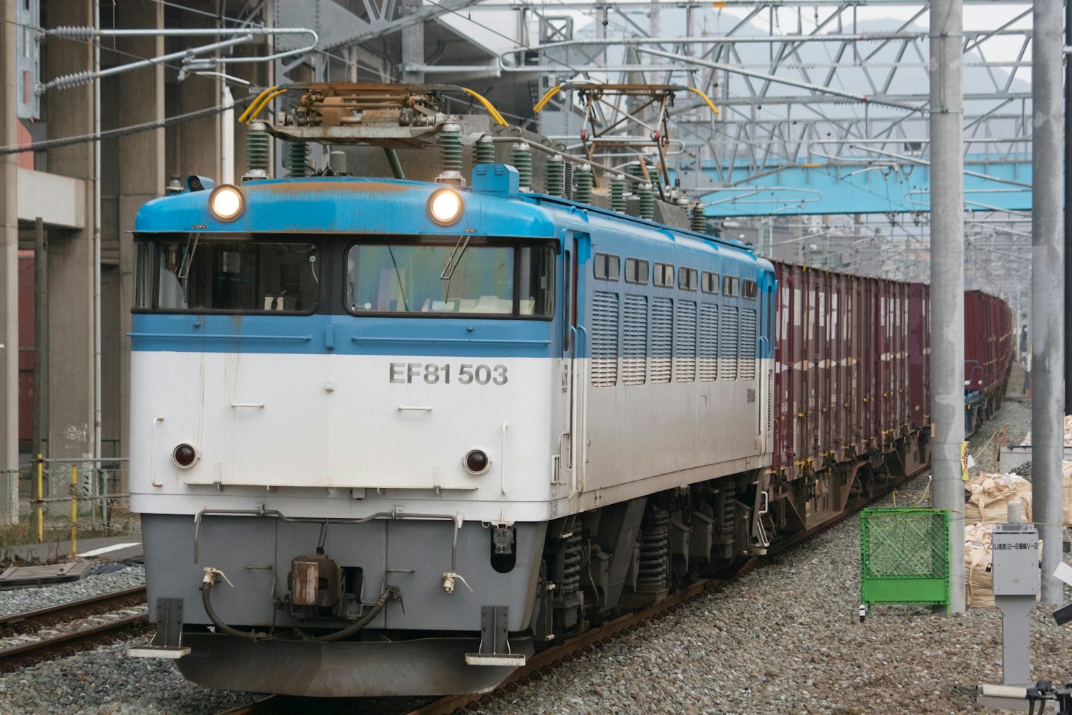 Blue and white electric locomotive pulling a freight train