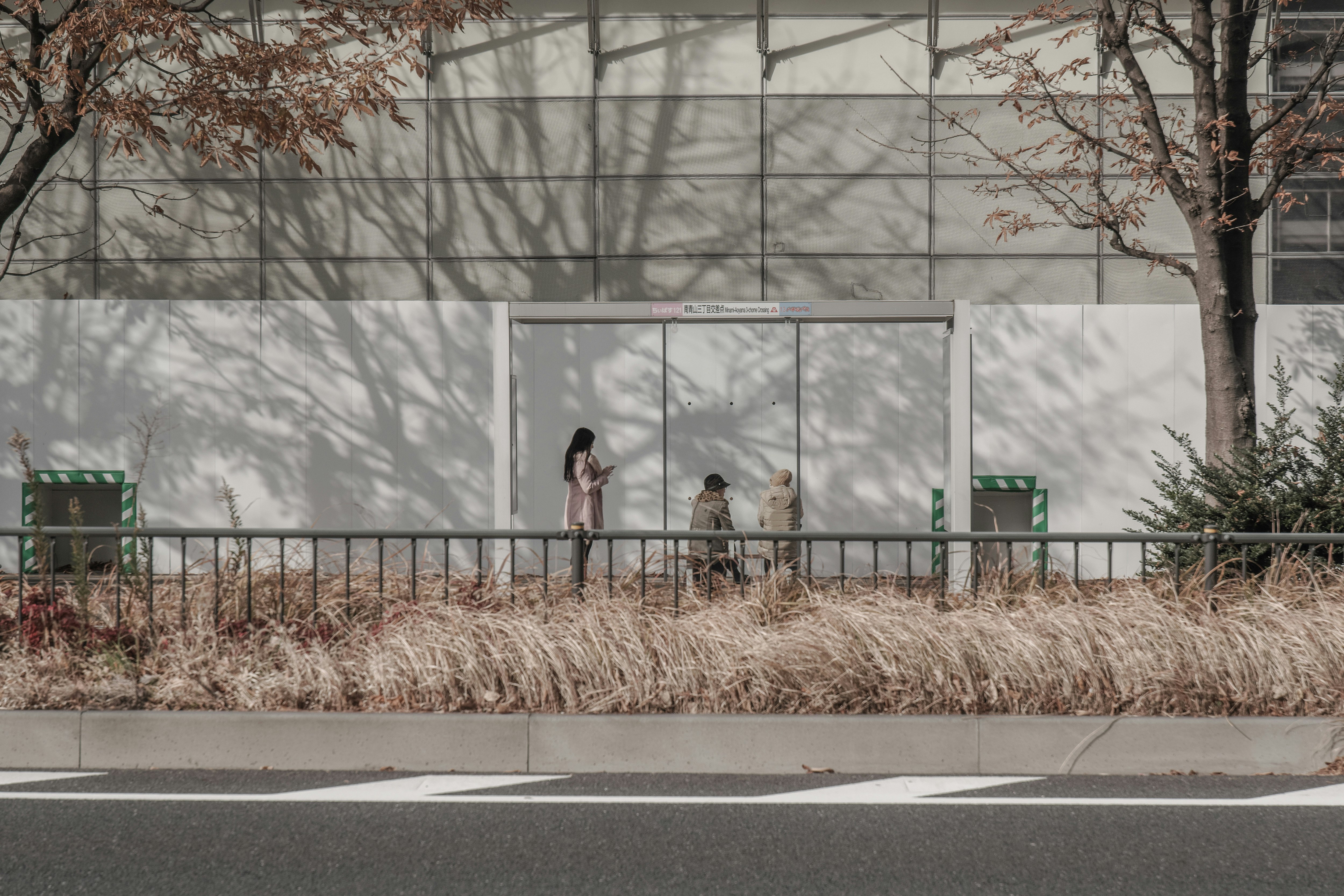 バス停のベンチ前で人が待つ街角の風景