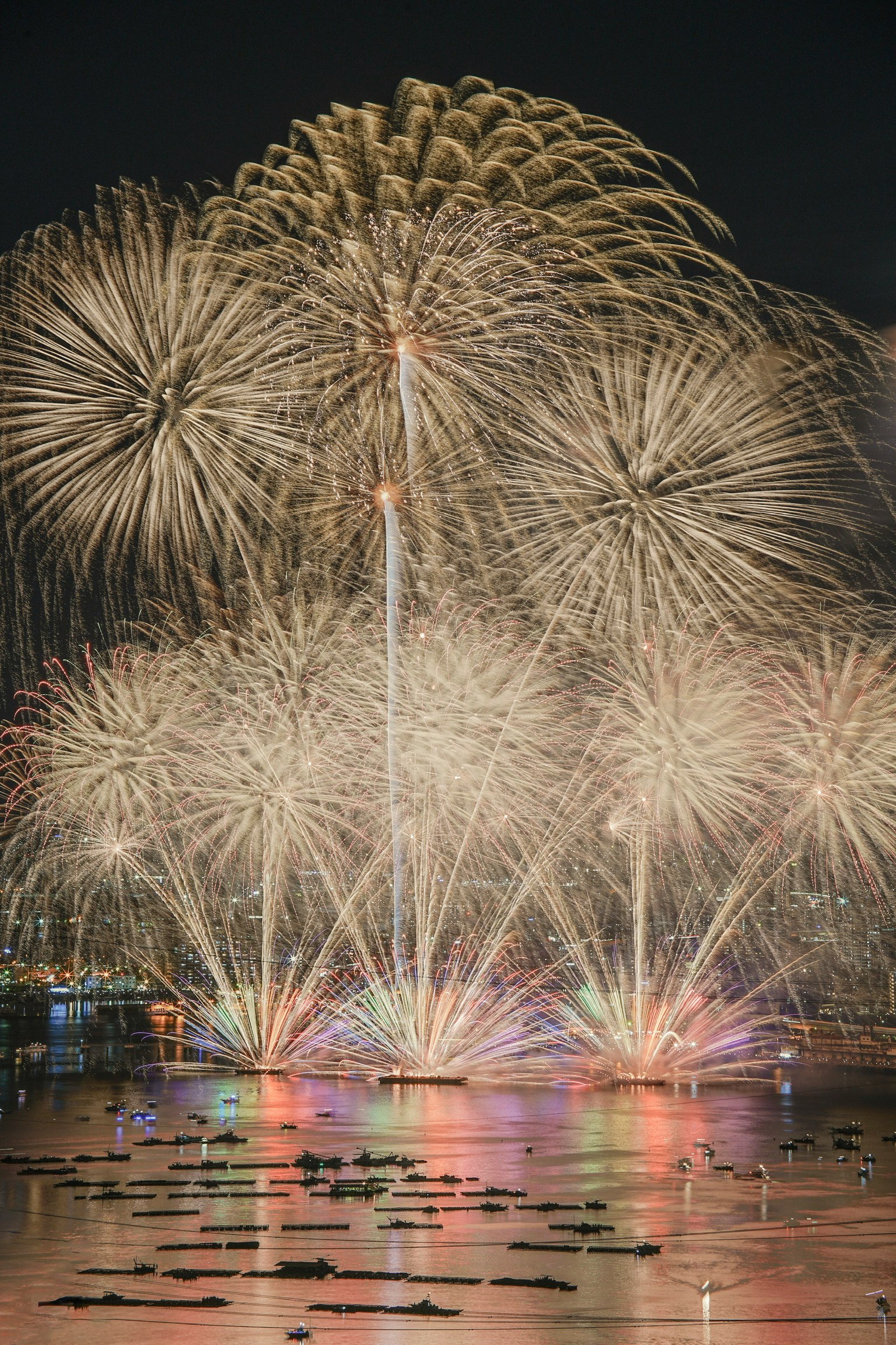 Fuochi d'artificio colorati esplodono nel cielo notturno riflessi nell'acqua
