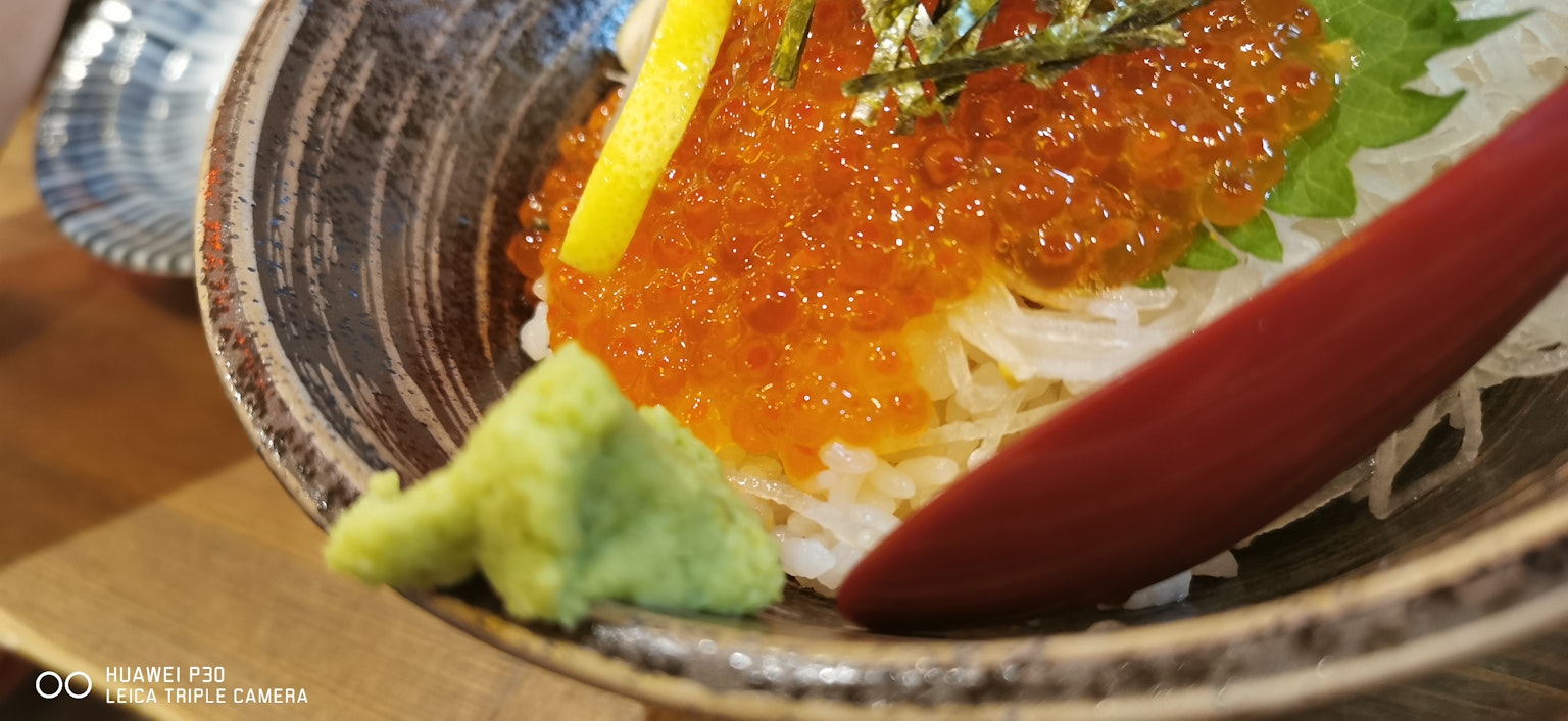 Piatto di frutti di mare splendidamente presentato con ikura e wasabi guarnito con verdure fresche e fette di agrumi