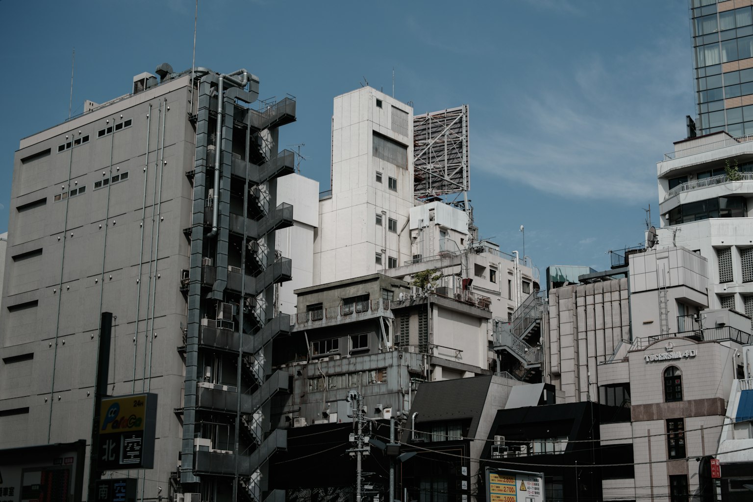 城市天际线，现代与老旧建筑混合，蓝天背景
