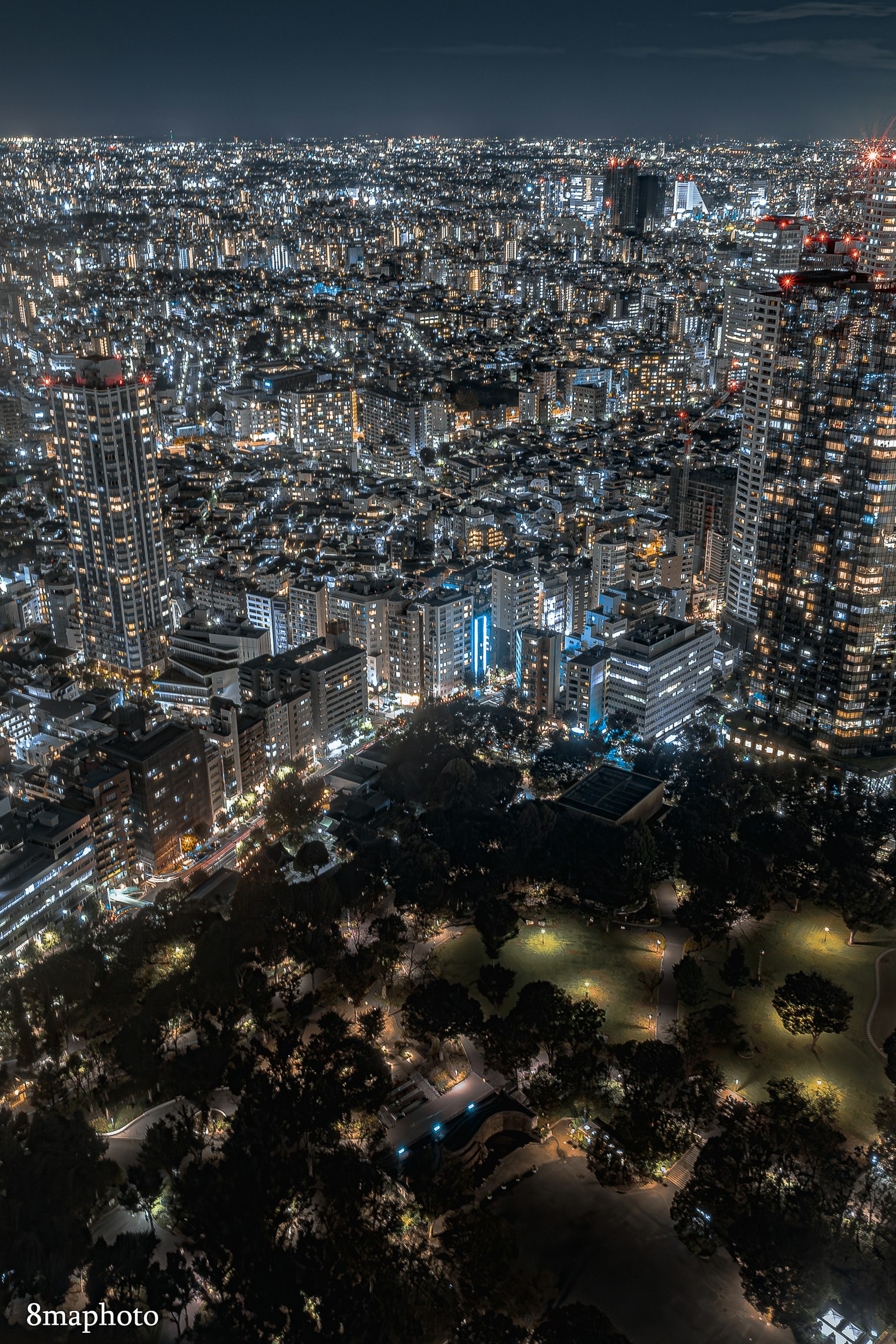 東京夜景展示摩天大樓與公園的明亮城市燈光