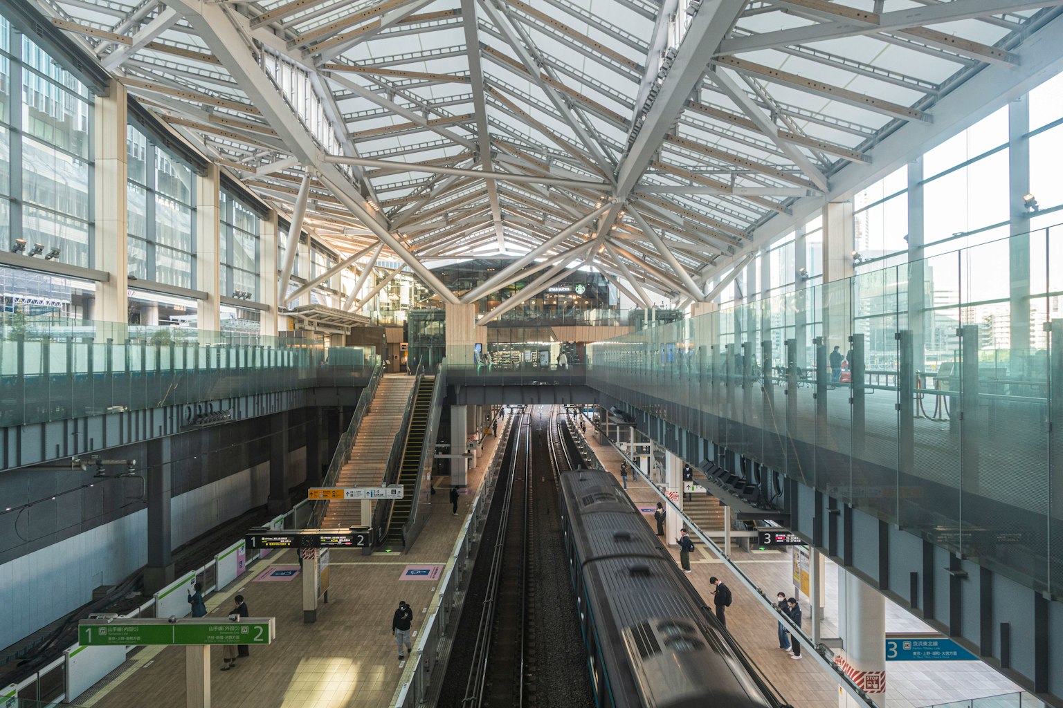 Intérieur moderne de la gare avec des quais de train et un plafond en verre