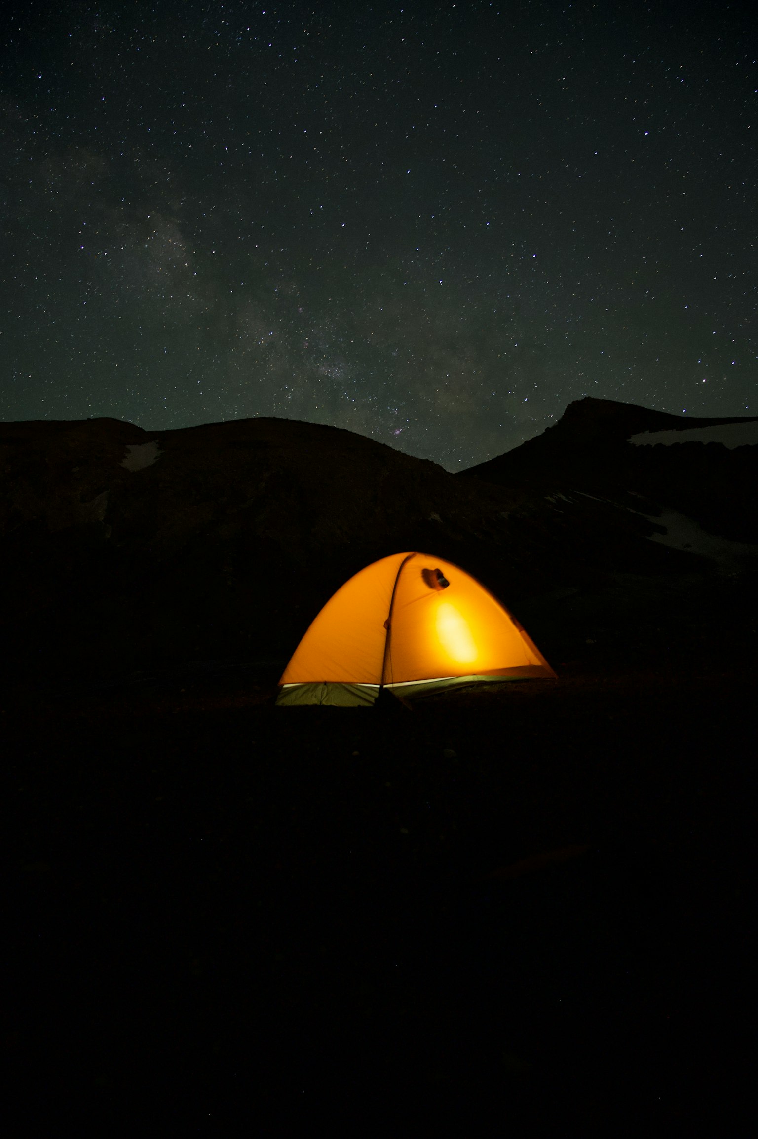 Tenda arancione brillante sotto un cielo stellato