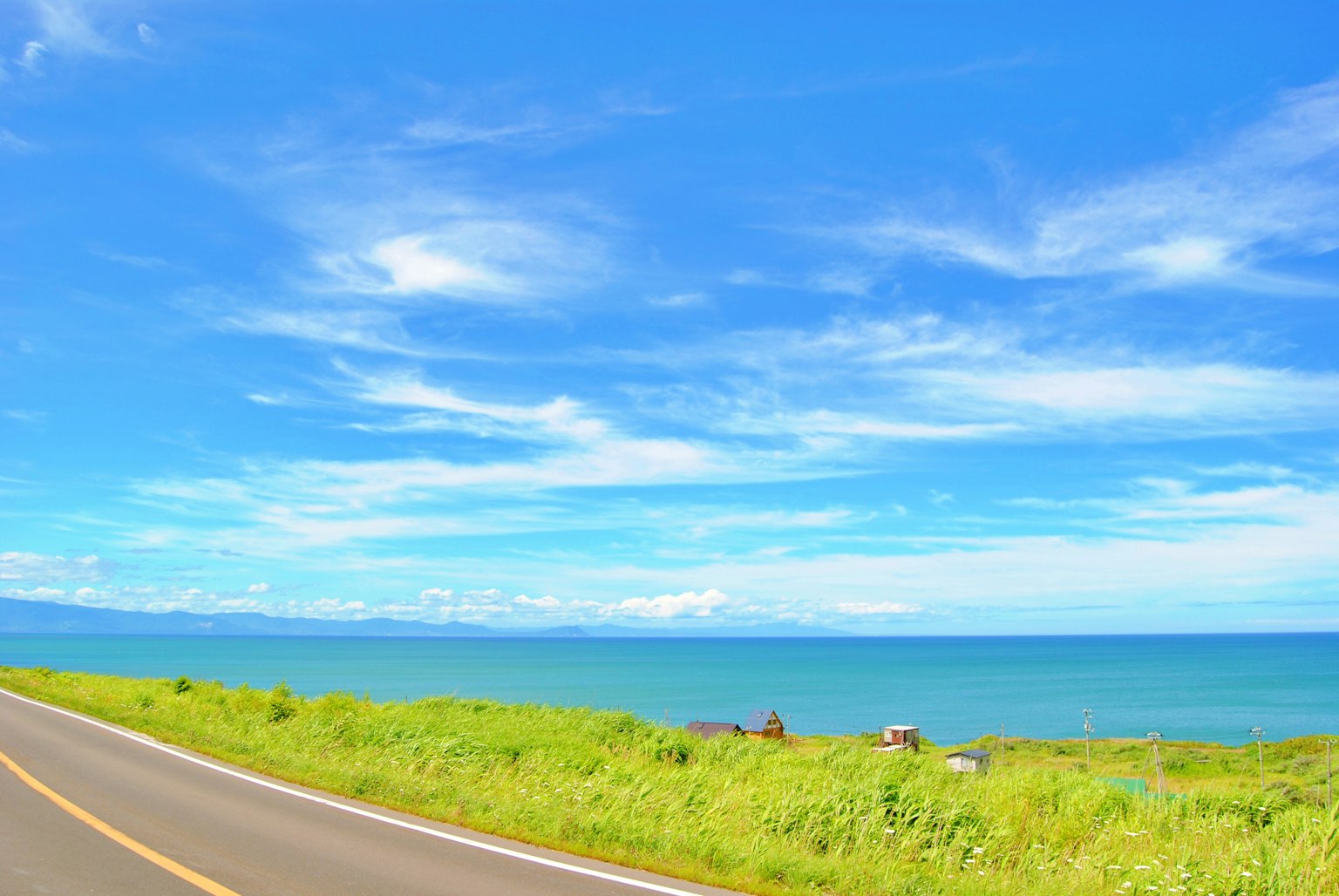 蓝色海洋和天空的风景 绿色草地和道路