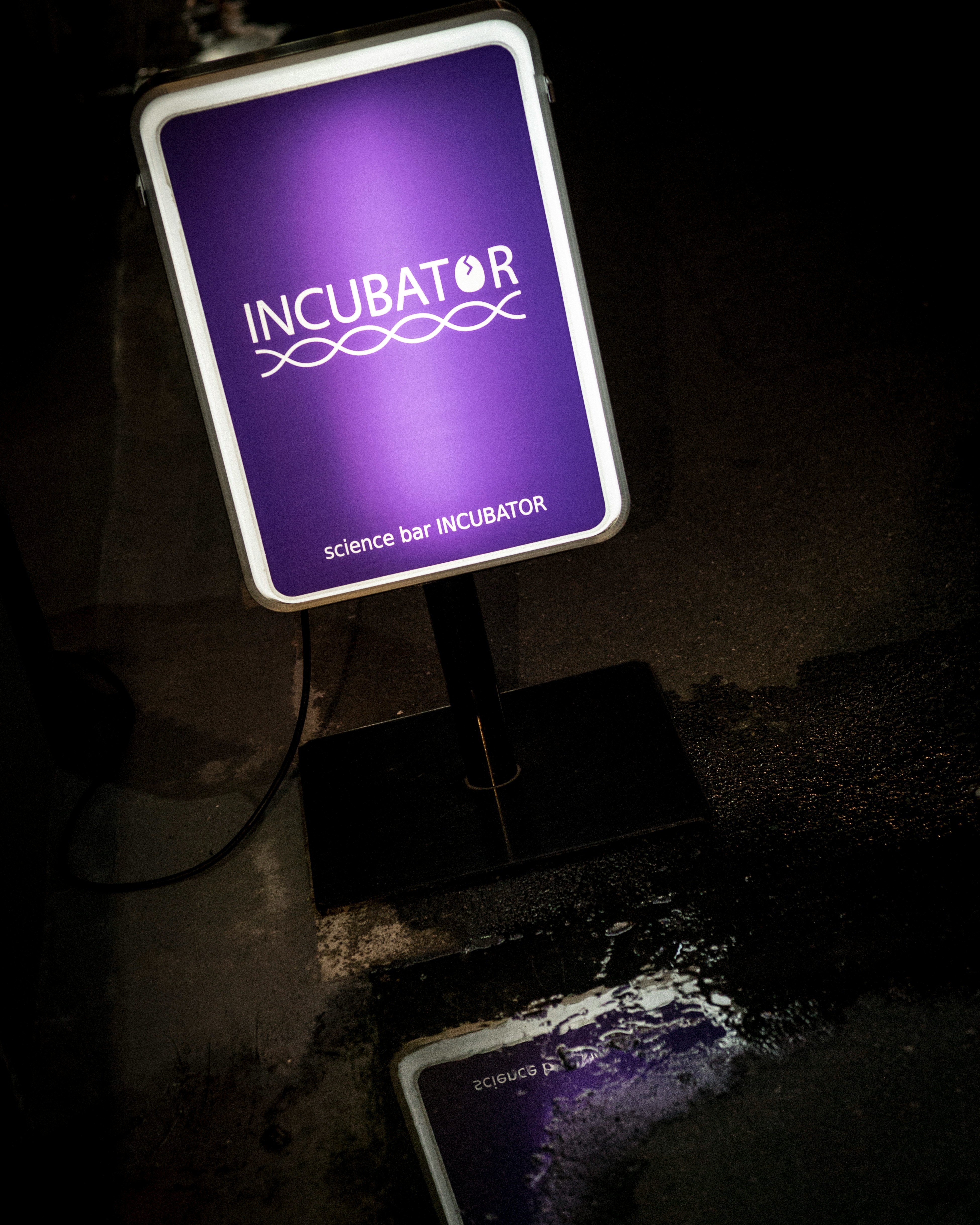 紫の「INCUBATOR」看板と科学用インキュベーターの展示