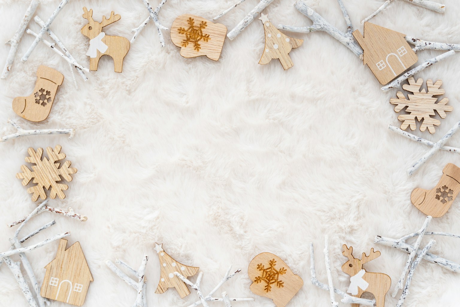 Susunan melingkar ornamen Natal kayu di latar belakang bersalju