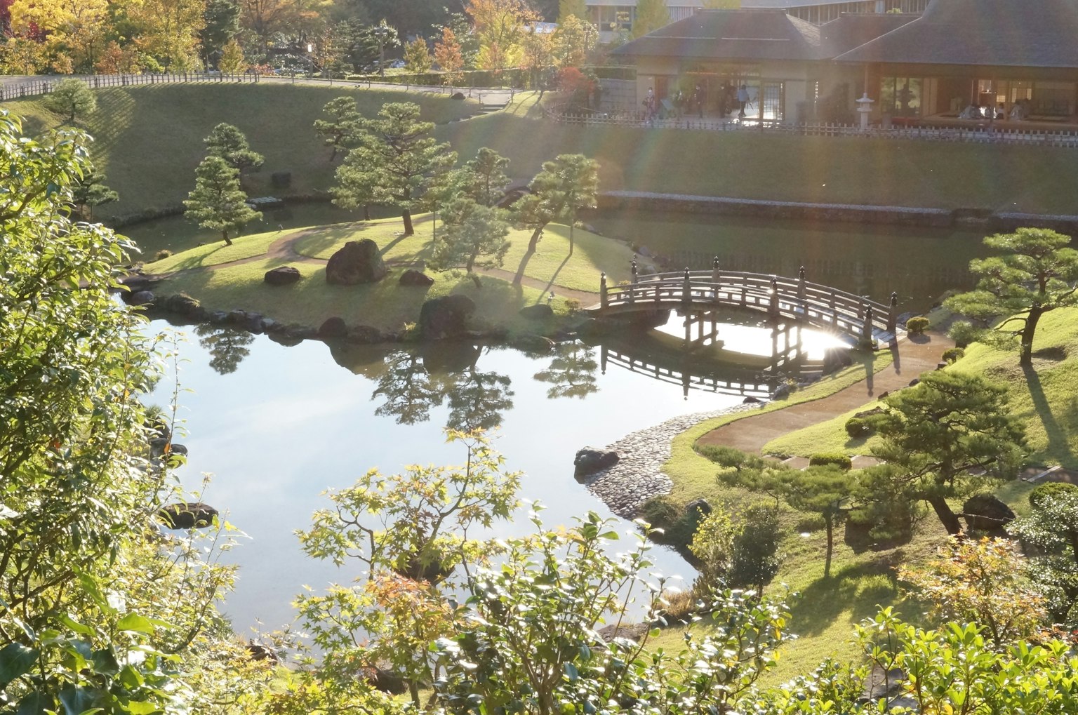 A beautiful Japanese garden scene featuring a bridge and reflections in the pond